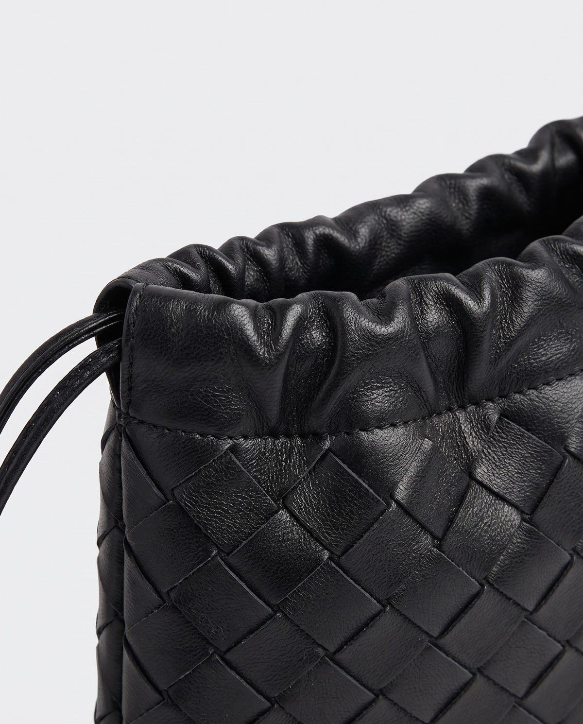 Serata woven leather clutch in black – drawstring detail