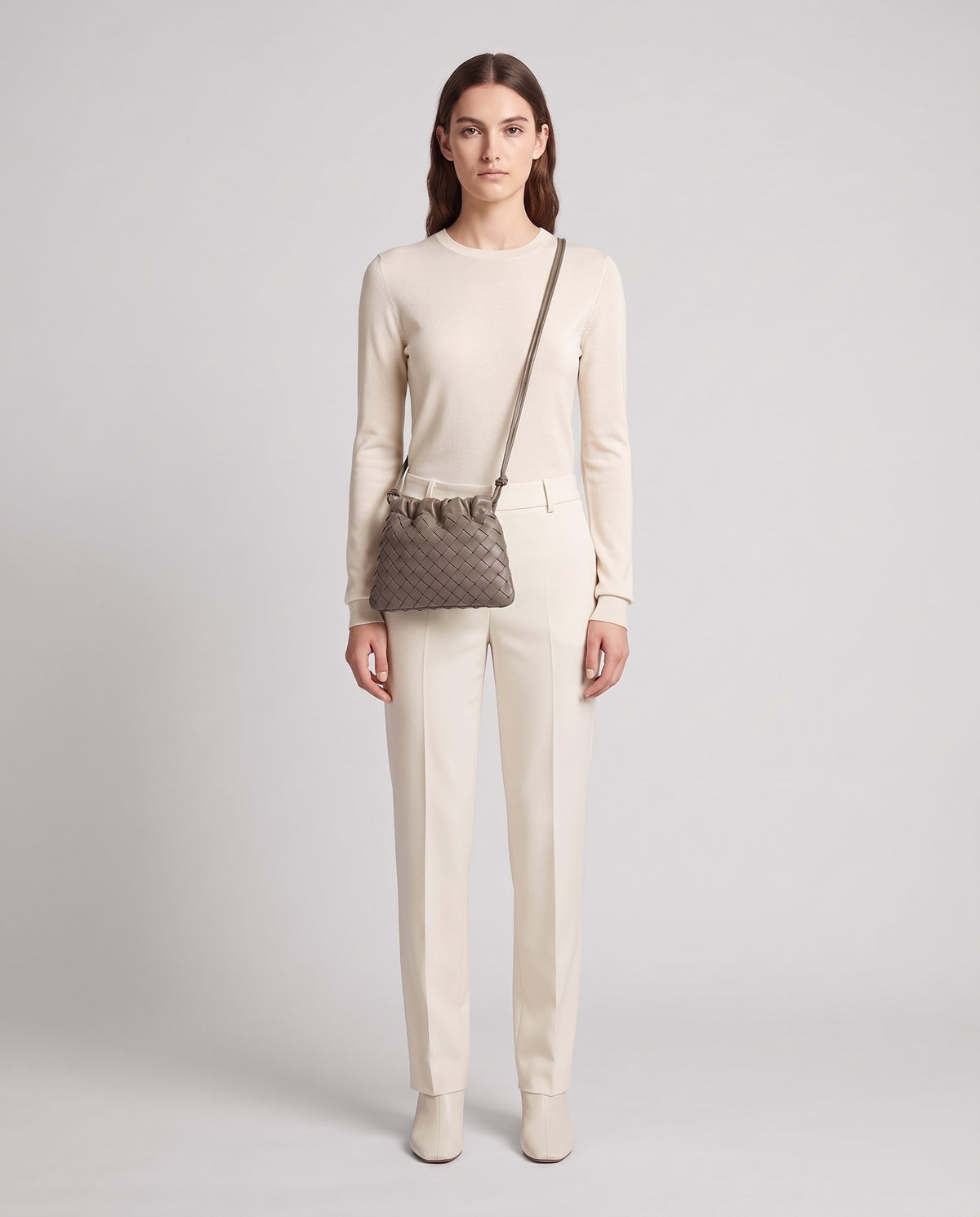 Model wearing the Serata woven leather clutch in Taupe – full length