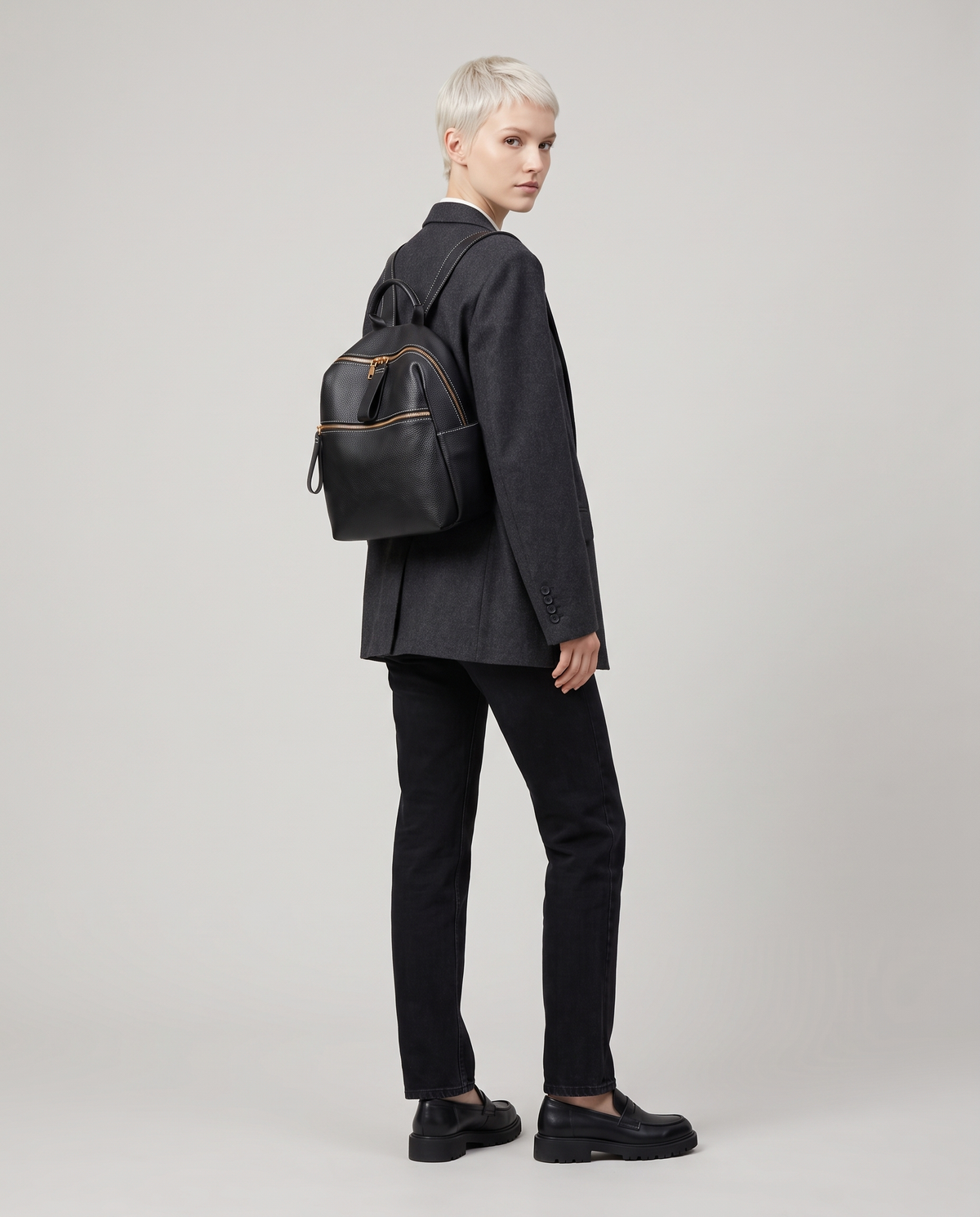 Tab pebbled leather backpack in Black – model wearing it on her back, full length