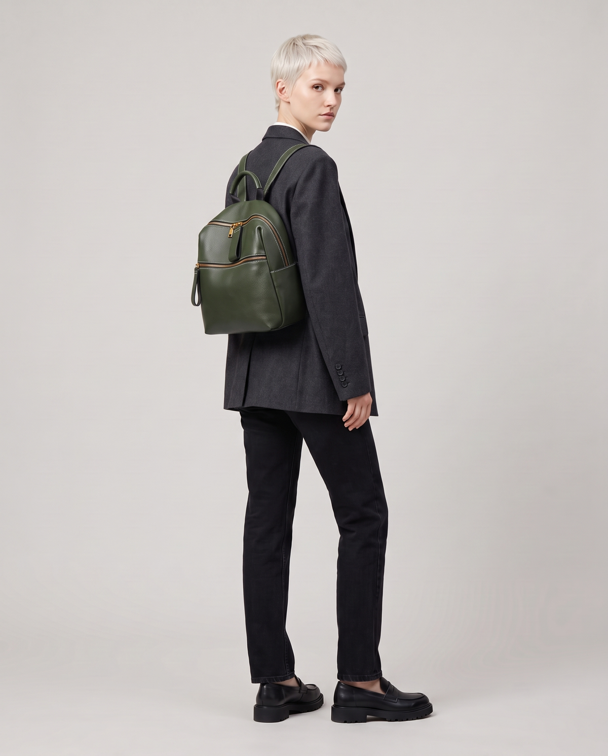 Tab pebbled leather backpack in Forest – model wearing it on her back, full length