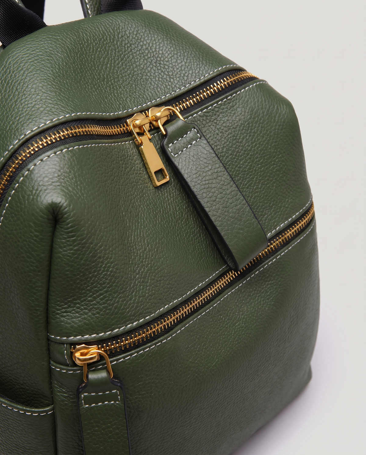 Tab pebbled leather backpack in Forest – close-up of the gold zips and pebbled leather