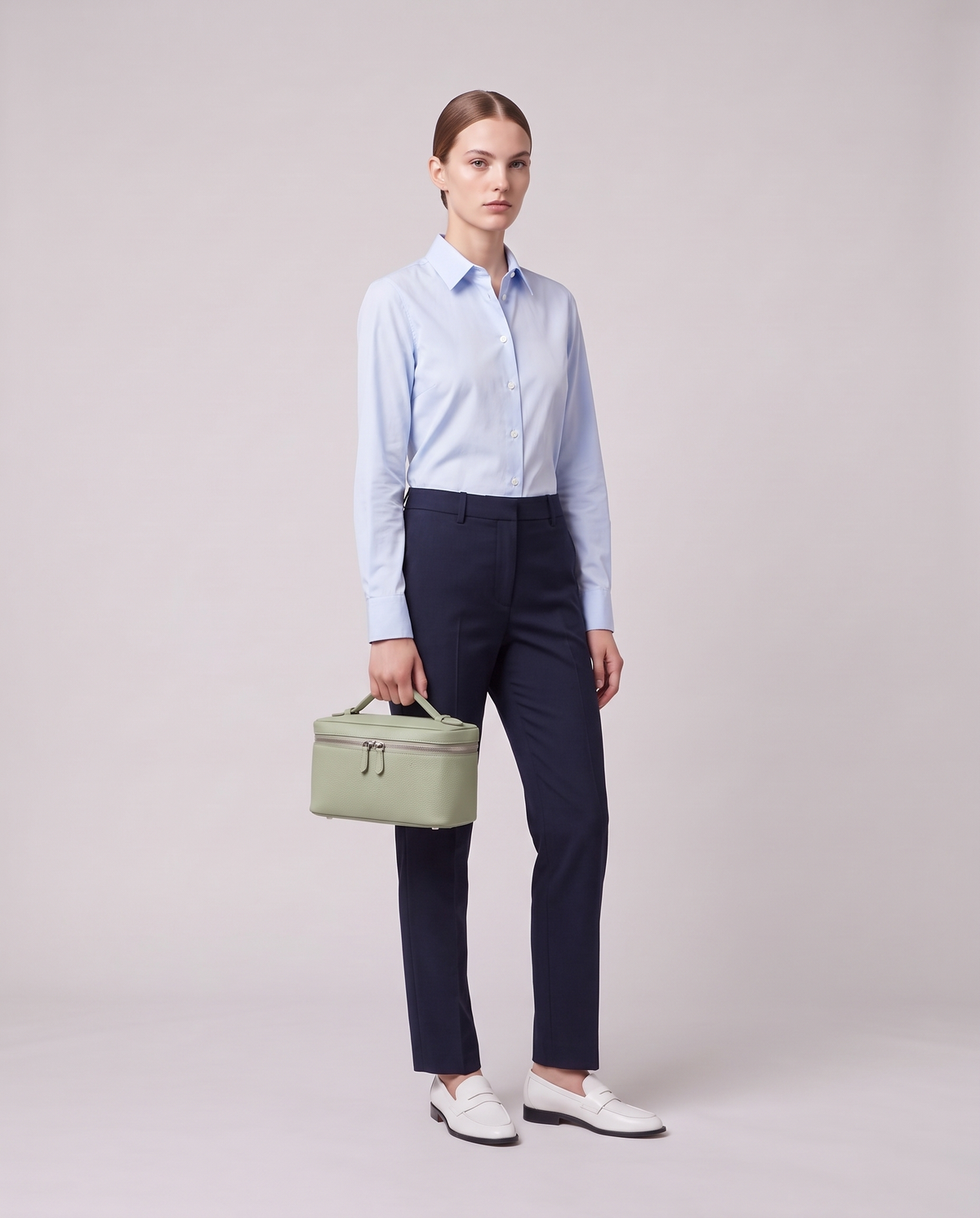 Model holding the Valentina Orvieto Small top-handle bag in Sage leather, full length