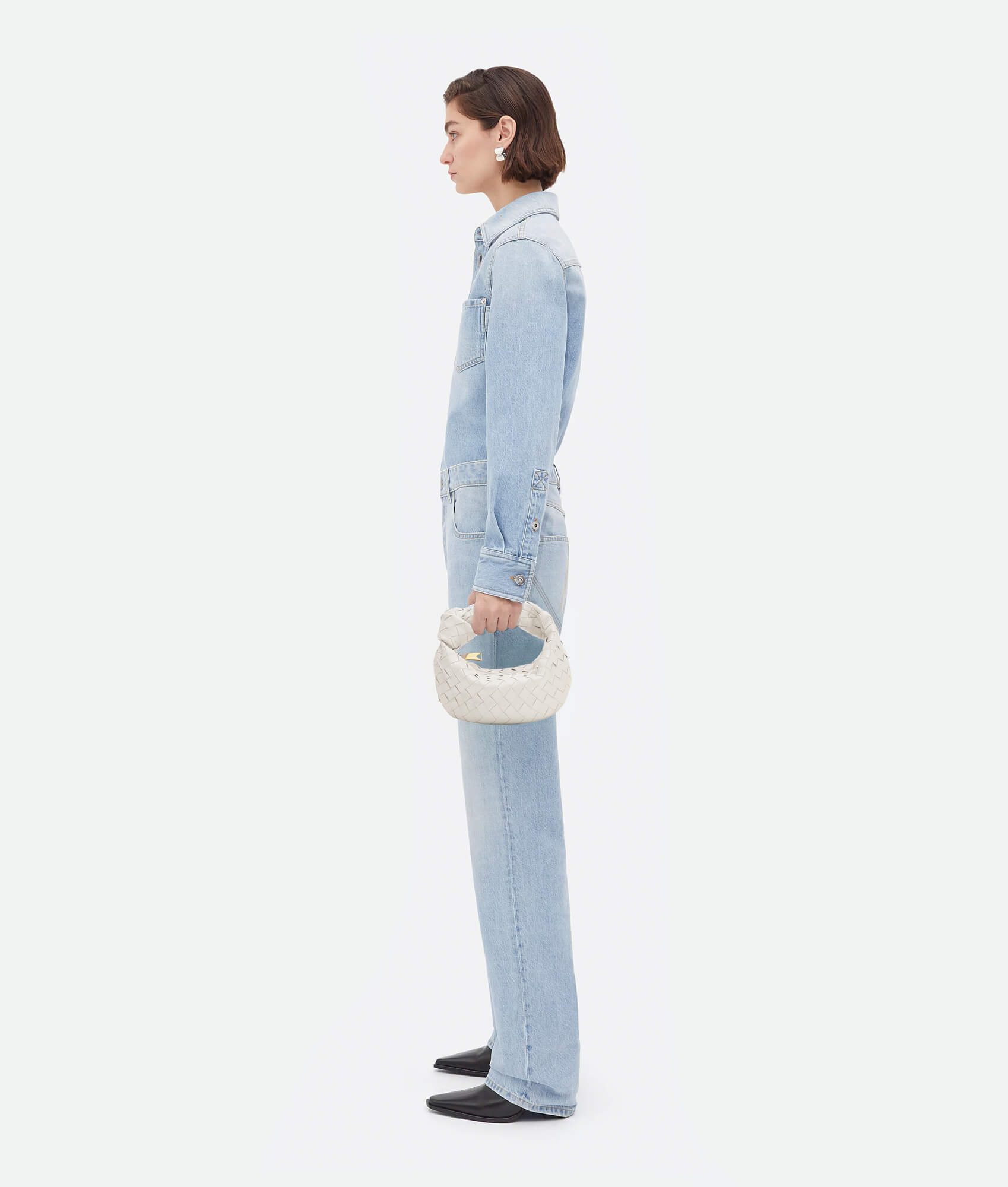 A white woven handbag inspired by the Bottega Mini Jodie design, featuring a compact and rounded shape.