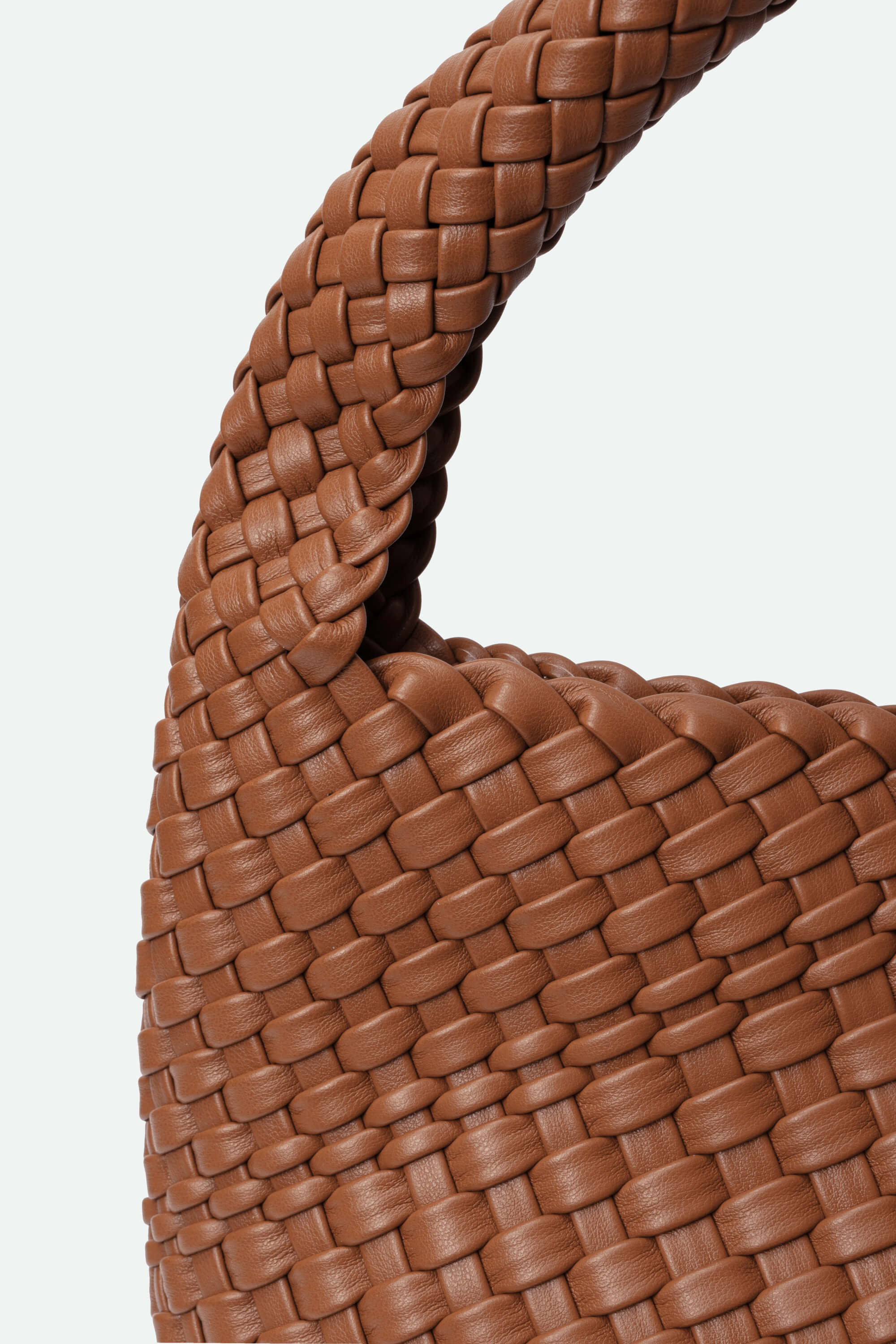 Close-up of a brown woven handbag handle on a white background