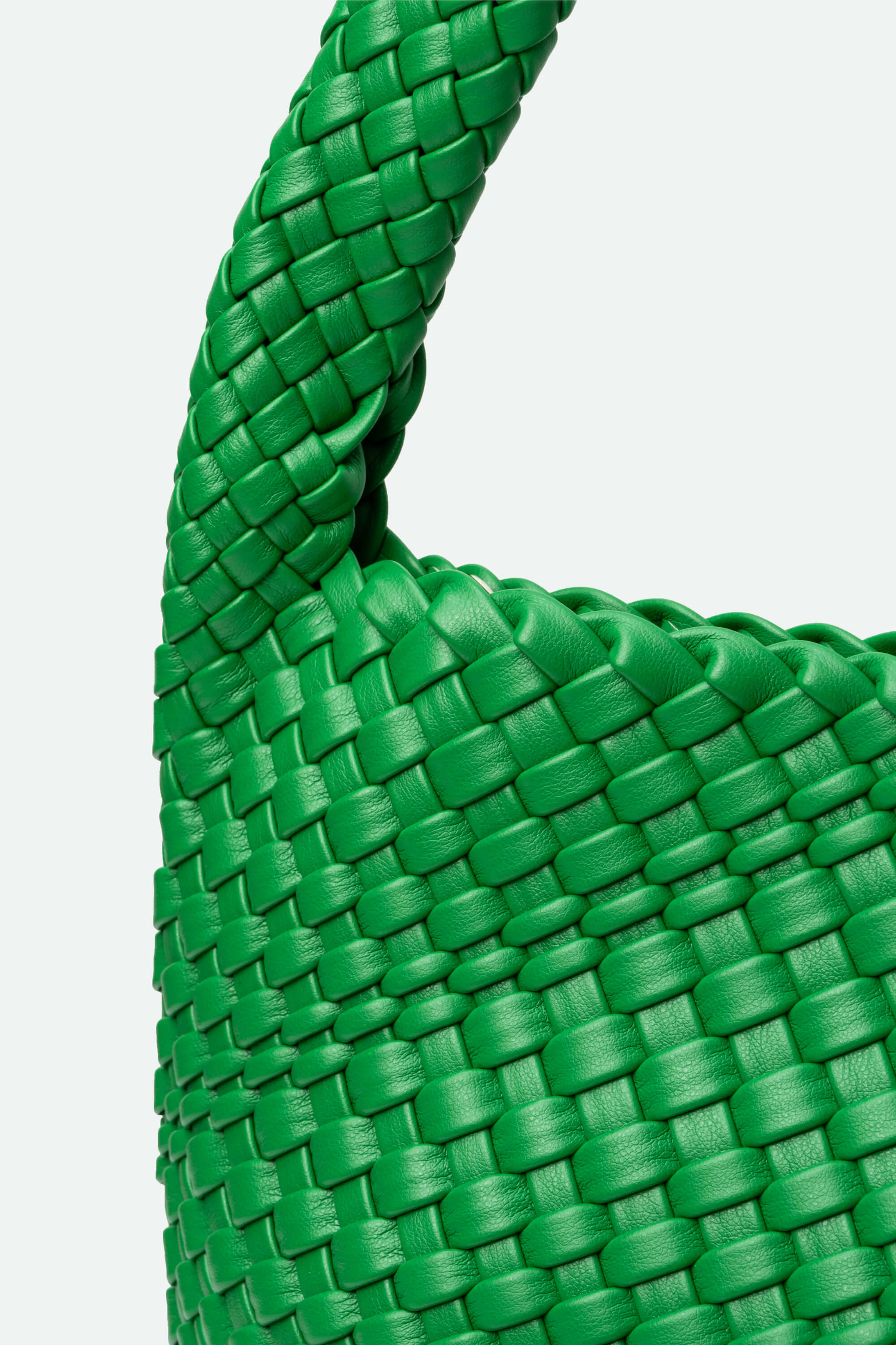 Close-up of a green woven bag on a light gray background