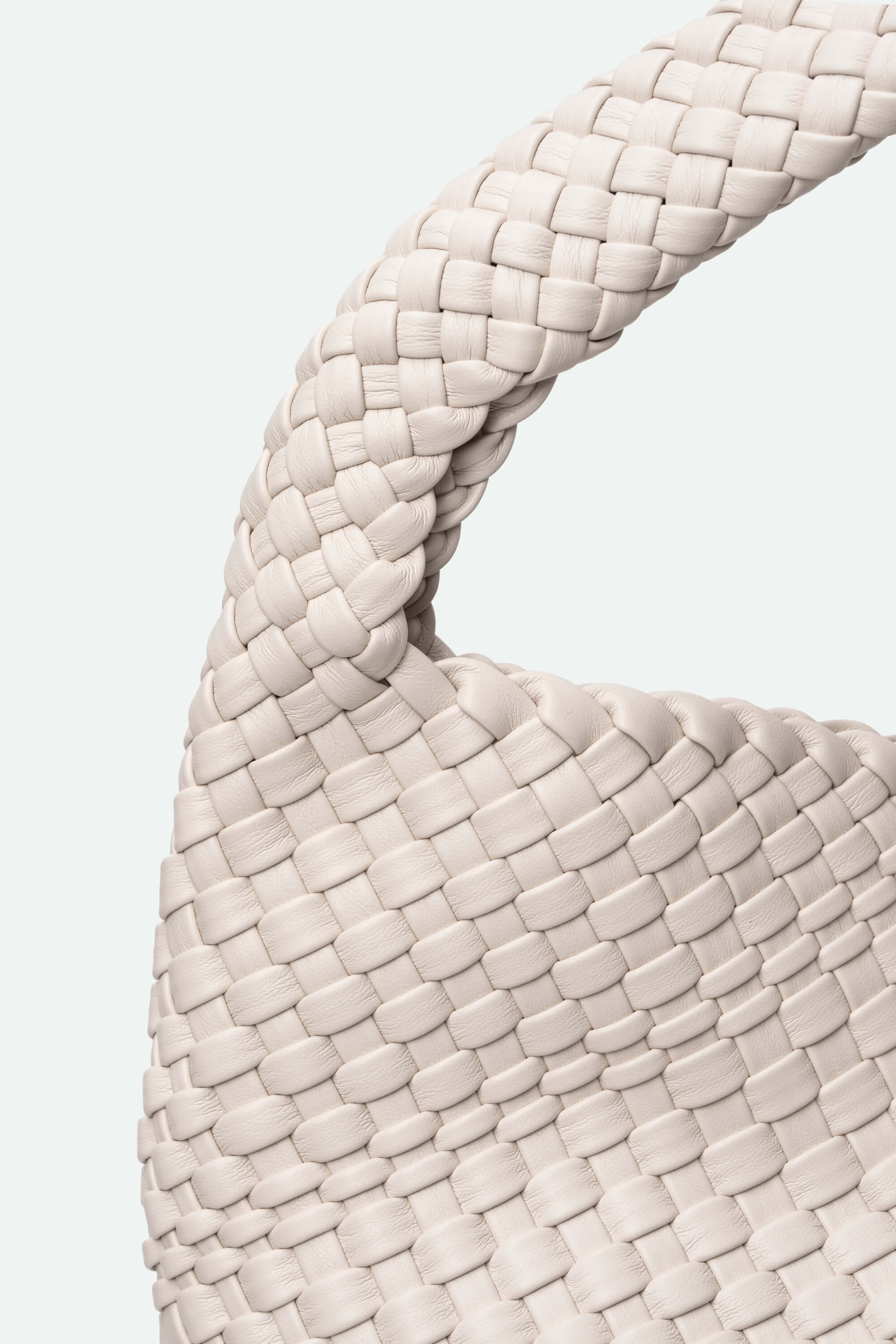 Close-up of a woven beige handbag on a light gray background