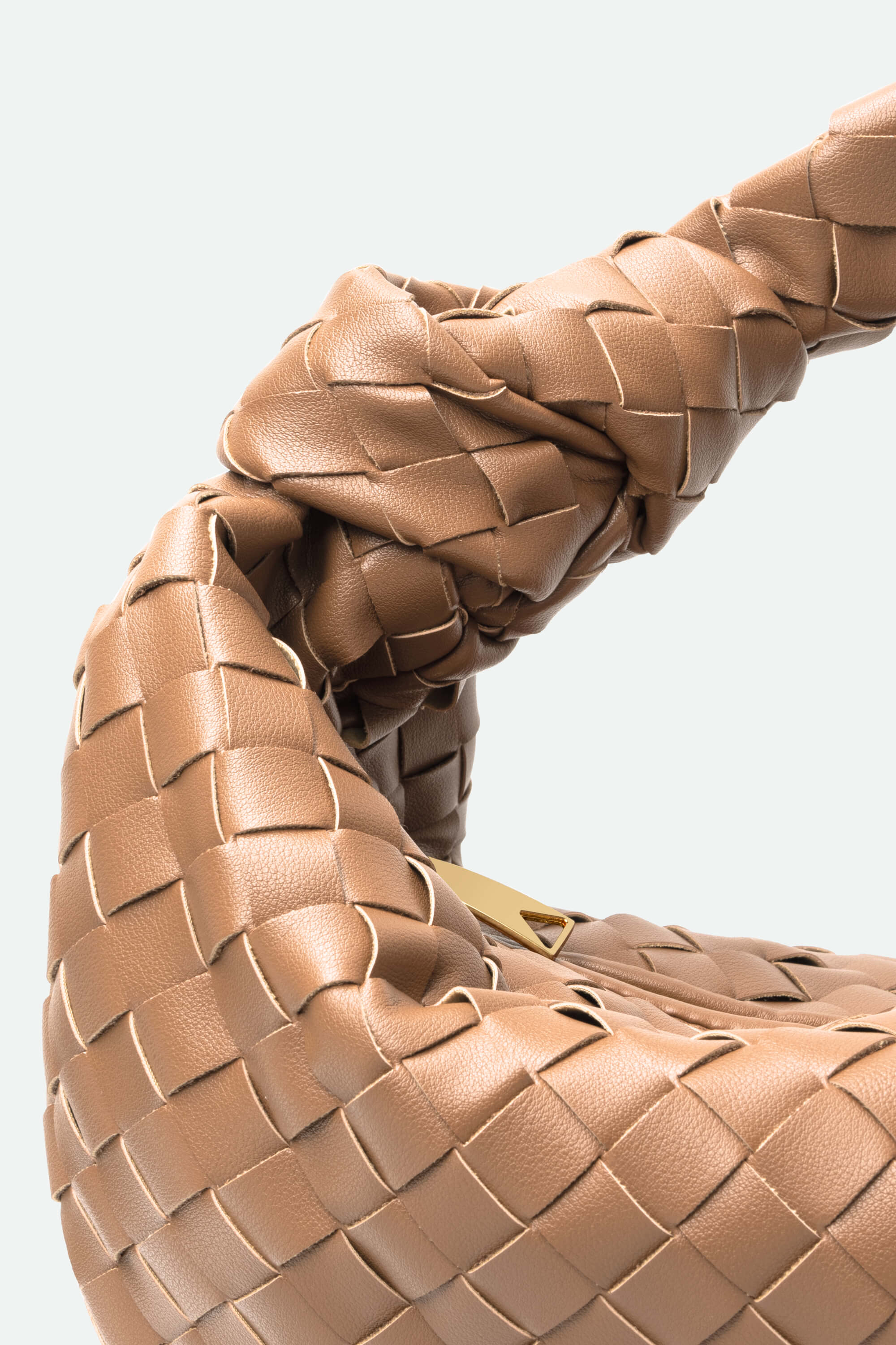 Close-up of a woven brown leather handbag on a light gray background