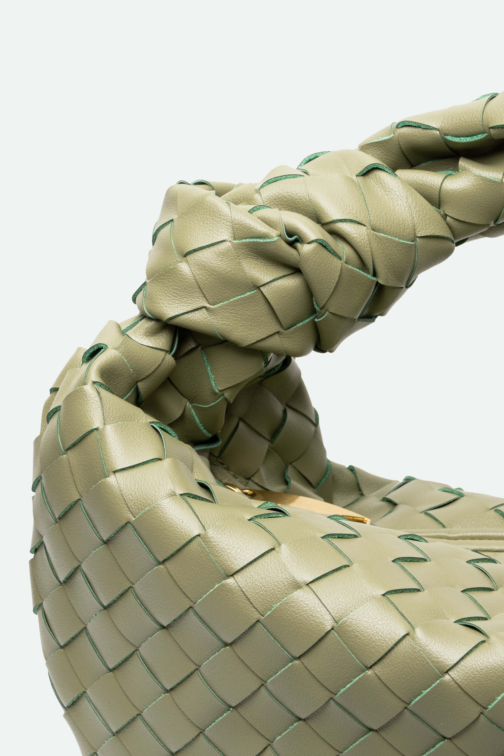 Close-up of a woven olive handbag handle on a light gray background