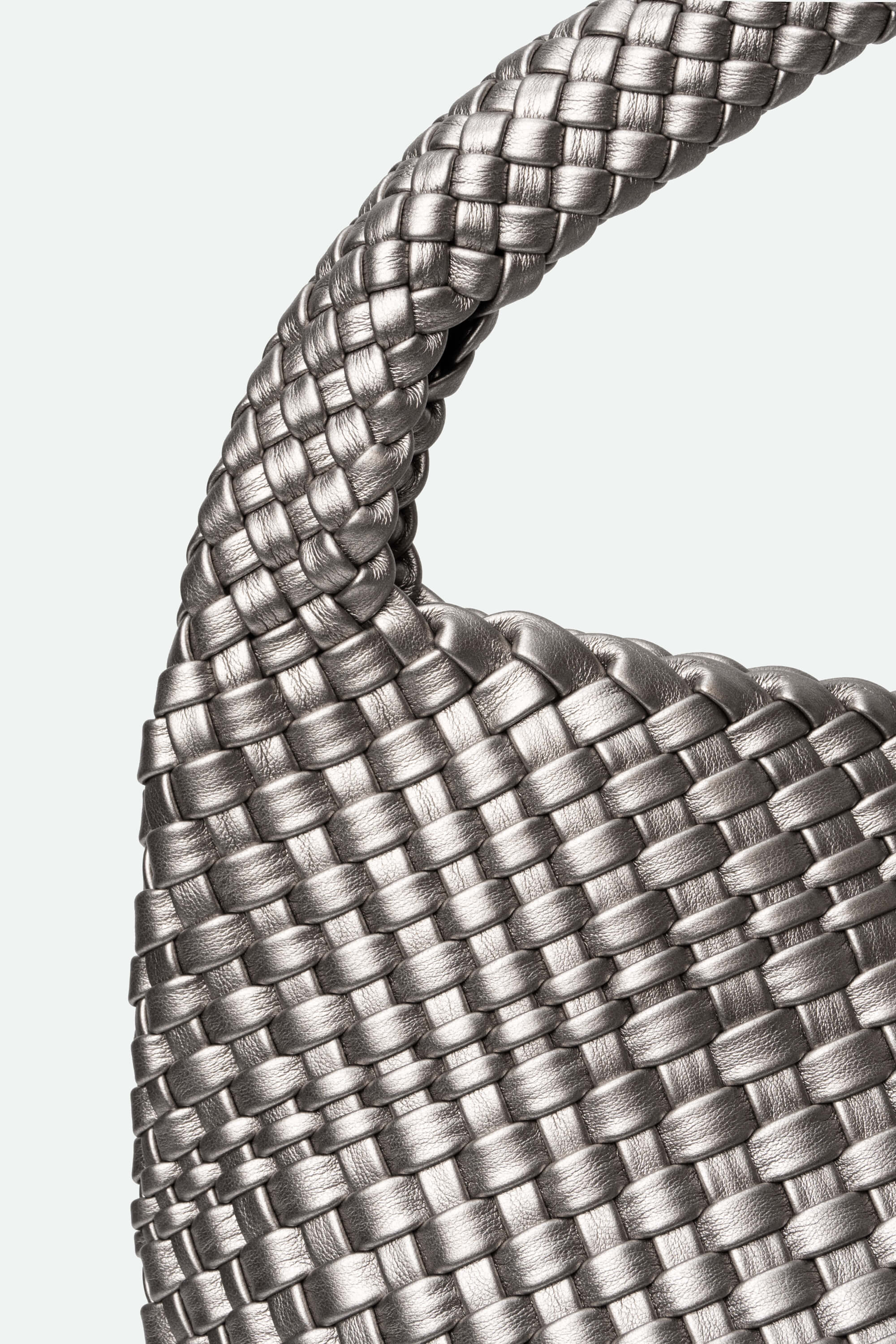 Close-up of a braided silver bag on a light gray background