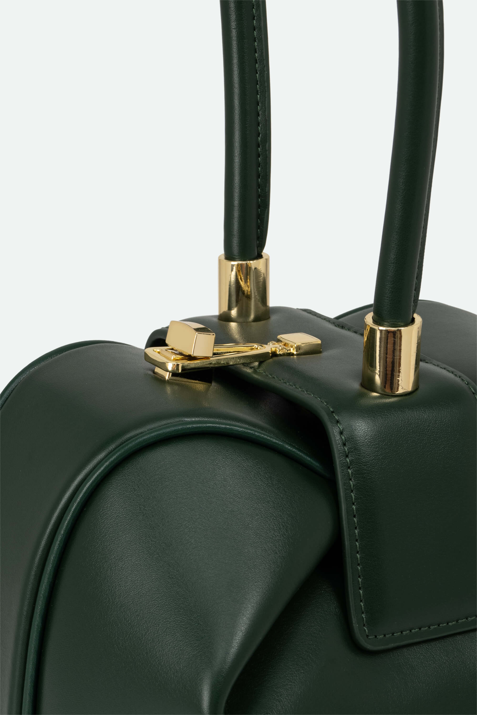Green handbag with gold clasp on a light gray background
