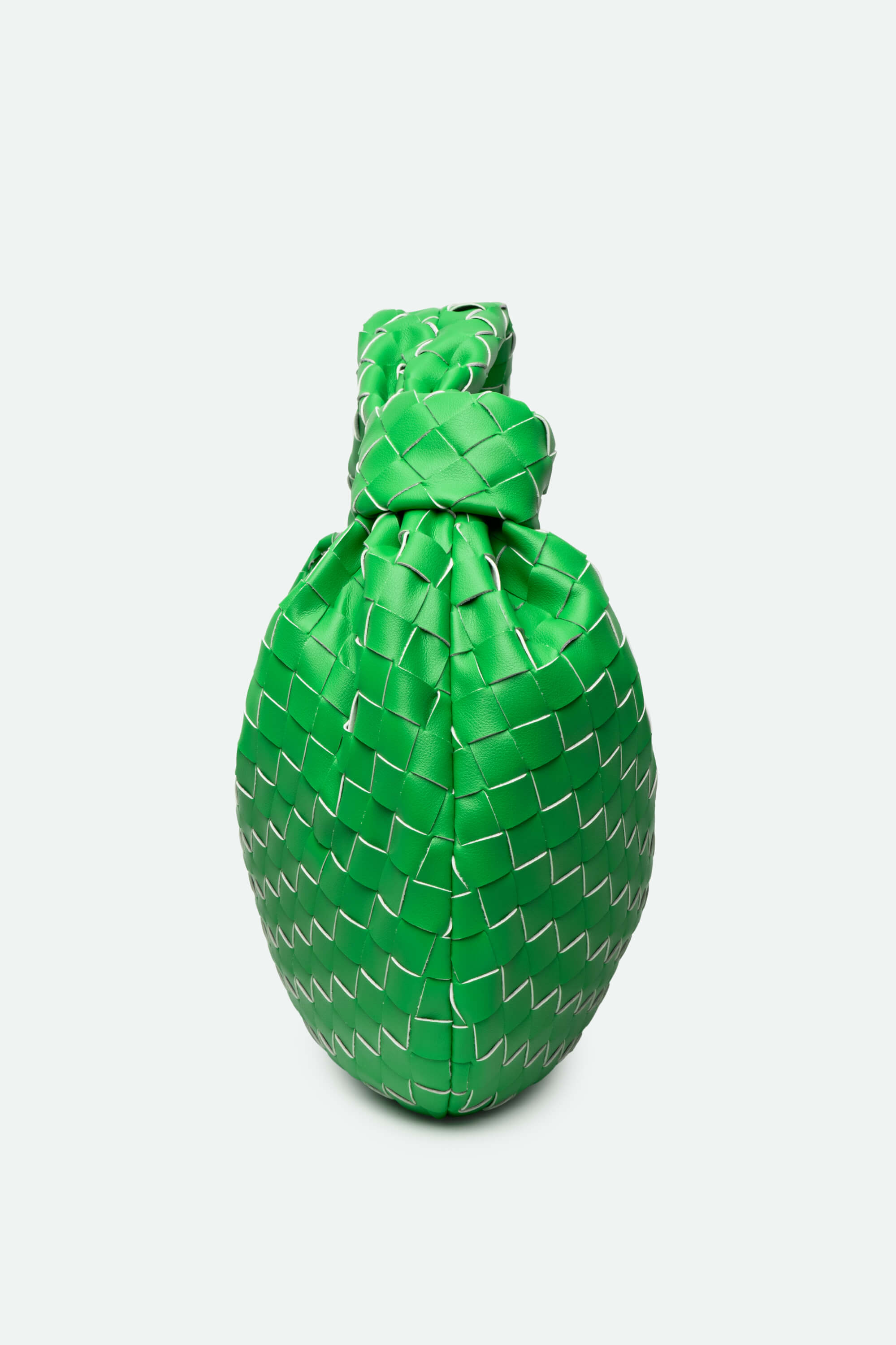 Green woven bag with a textured pattern on a white background