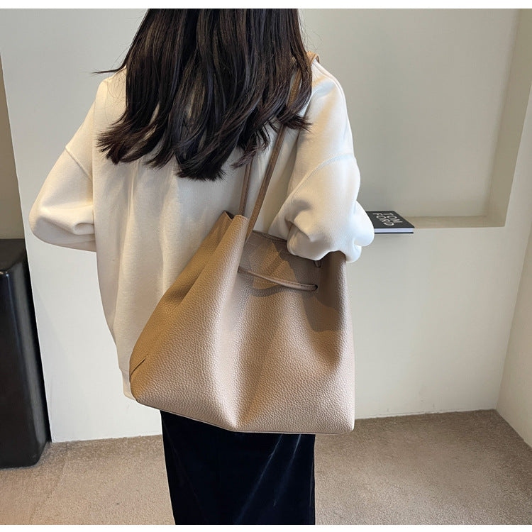 Person holding a beige handbag in an indoor setting
