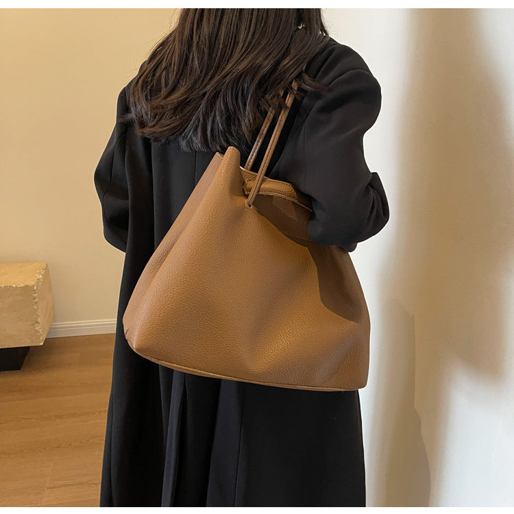 Person holding a brown leather handbag indoors