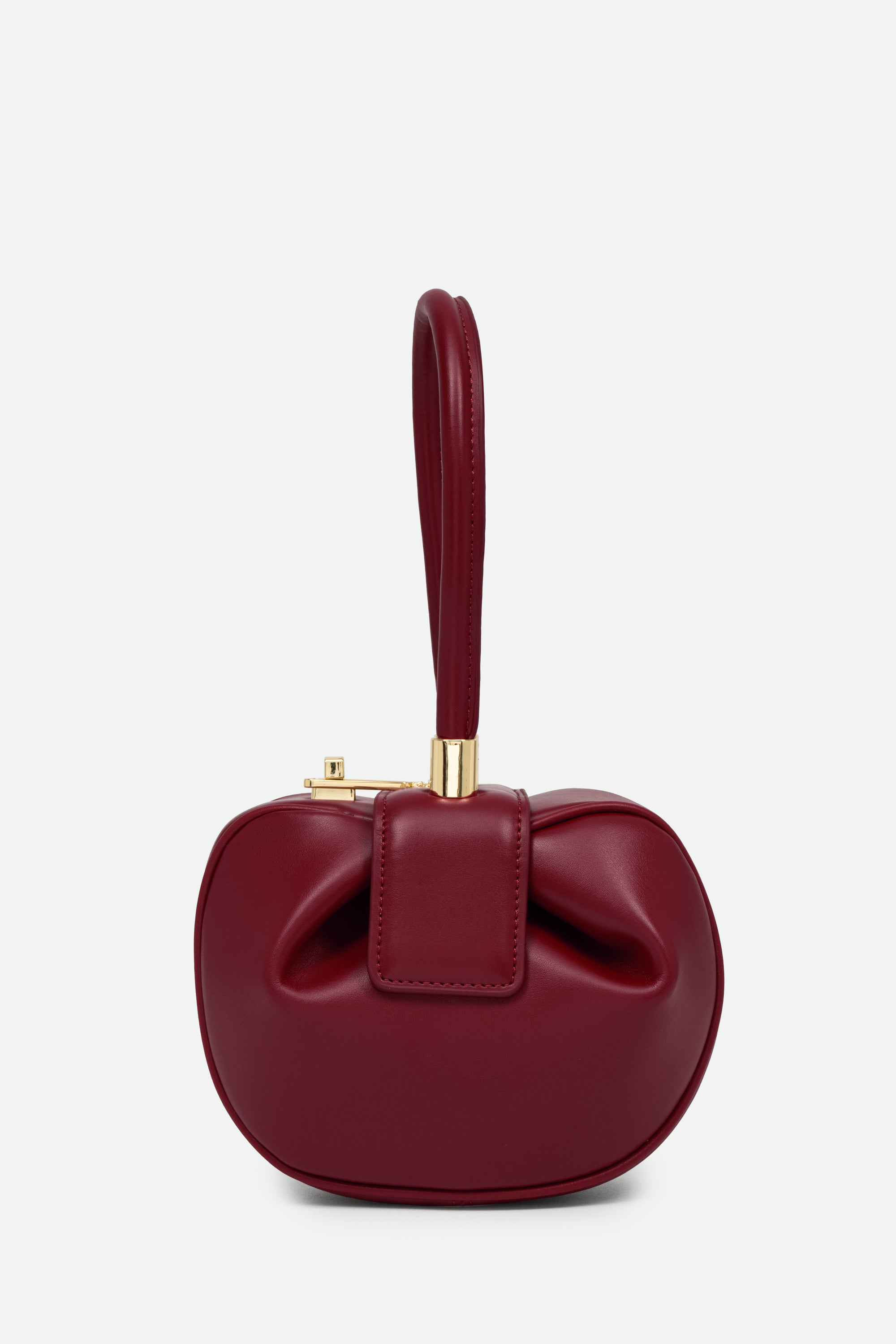 Red handbag with a bow detail on a light gray background