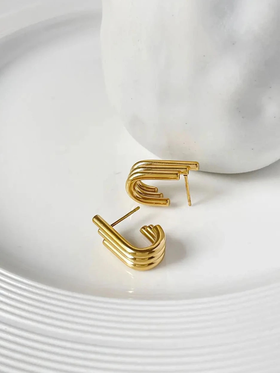 Gold Earrings On White Plate