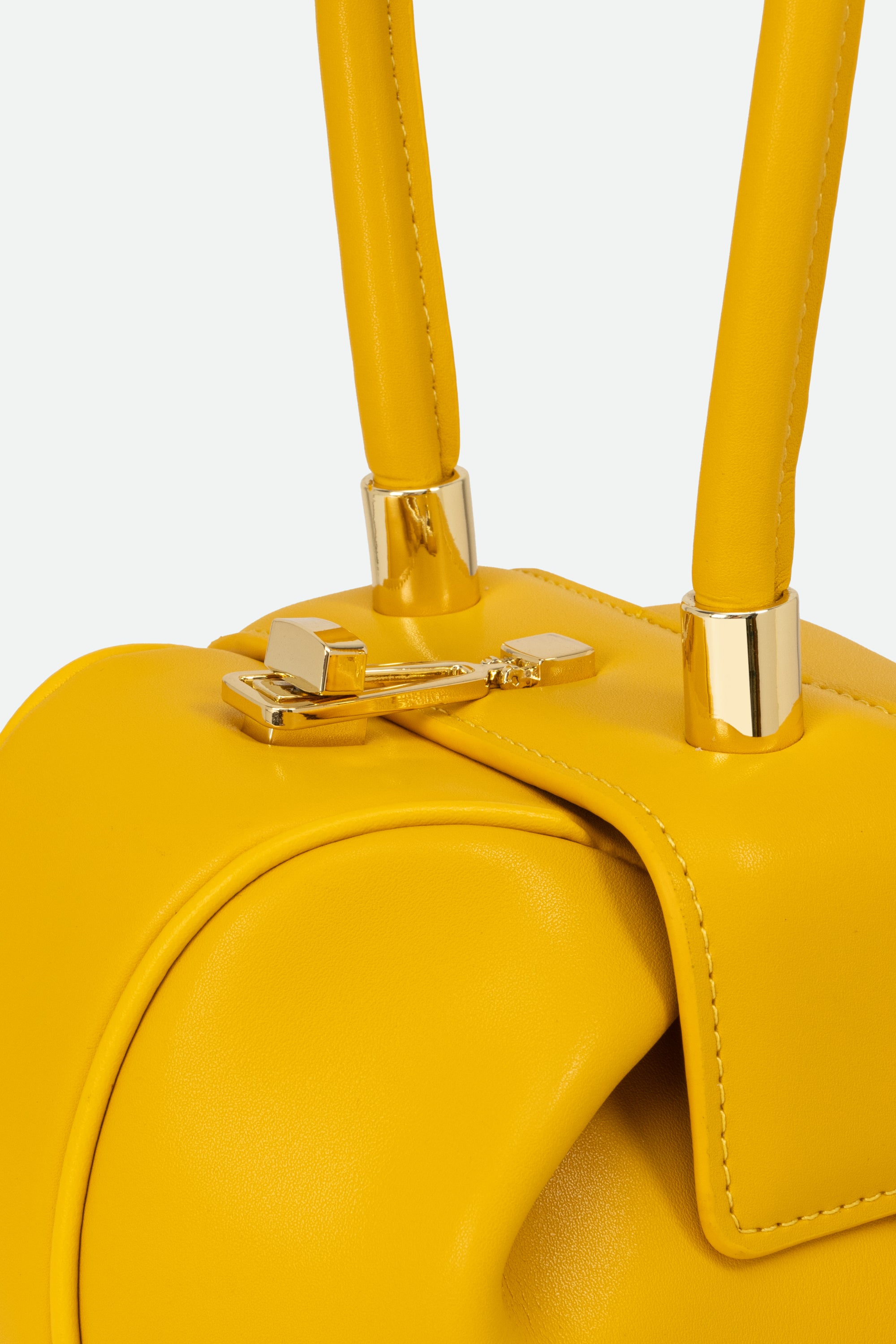 Yellow handbag with gold handles and clasp on a light gray background