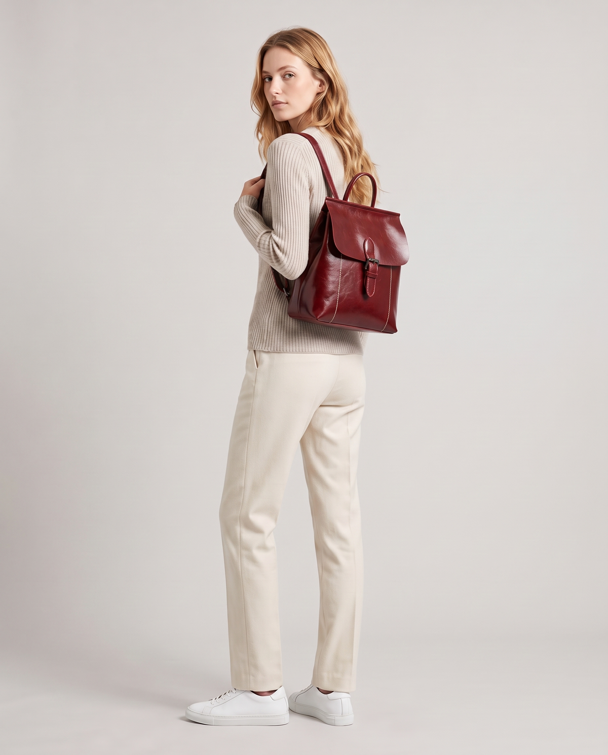 Ambler waxed leather backpack in Red – model wearing it on her back, full length