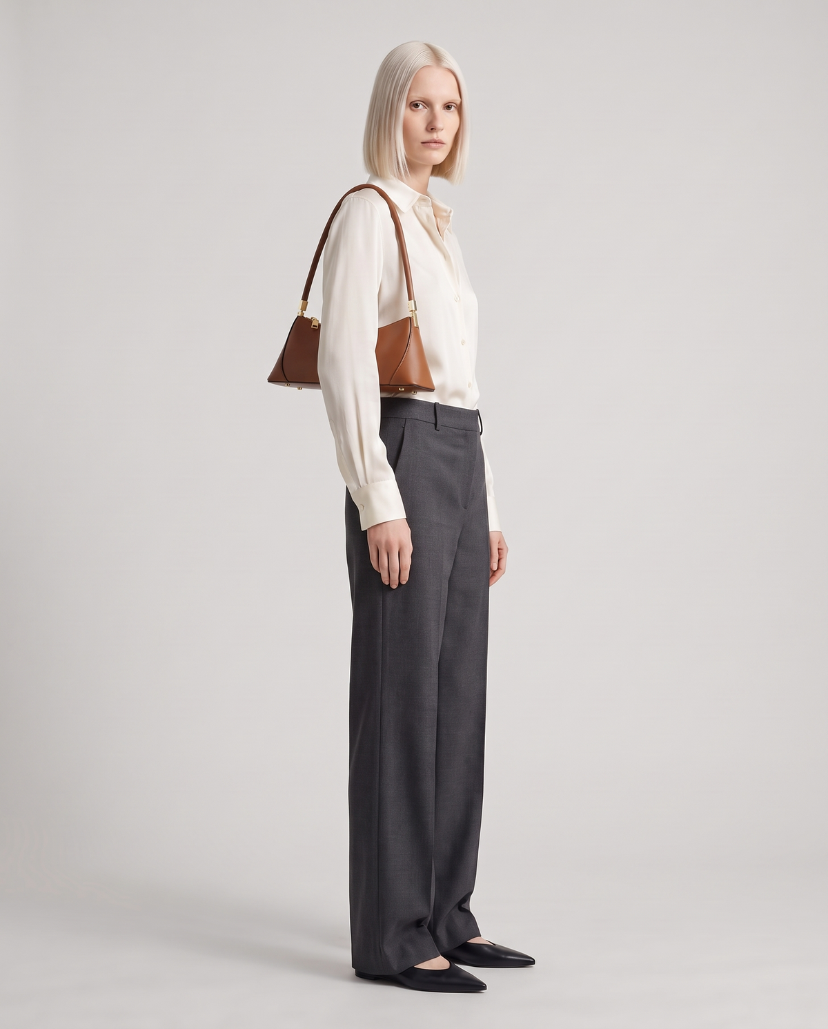 Arc leather shoulder bag in Brown – model wearing it on her shoulder, full length