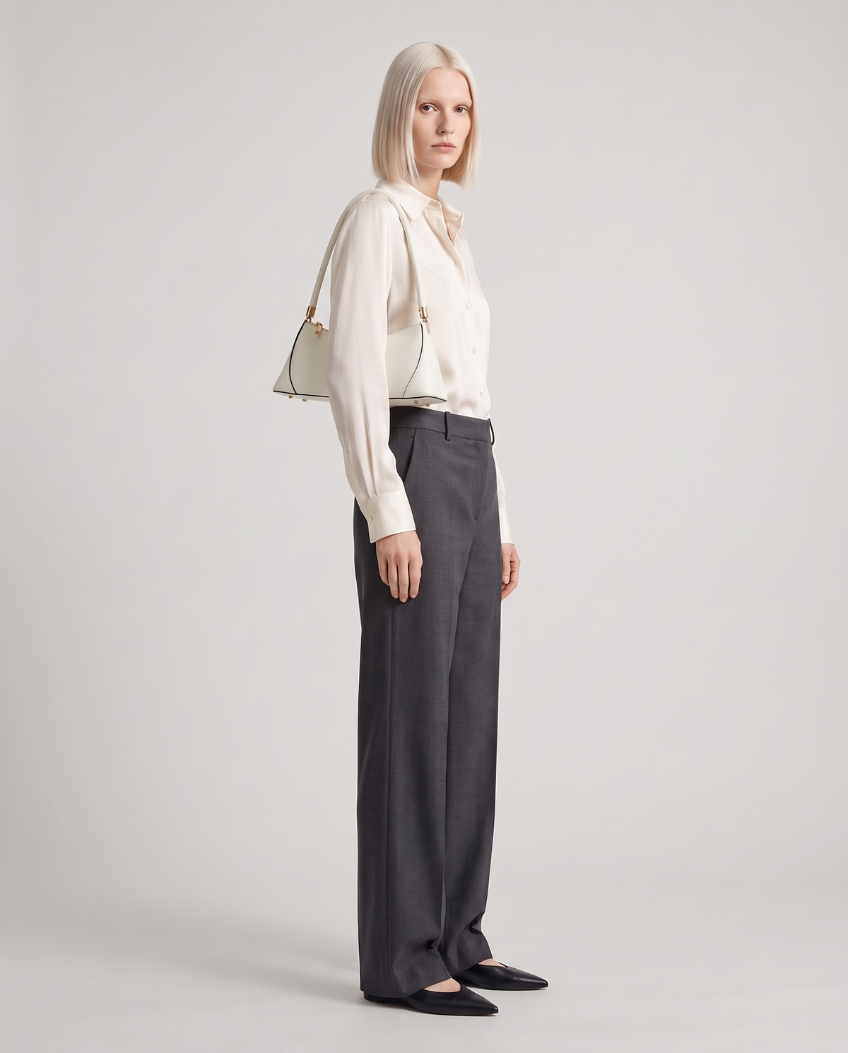Arc leather shoulder bag in Chalk – model wearing it on her shoulder, full length