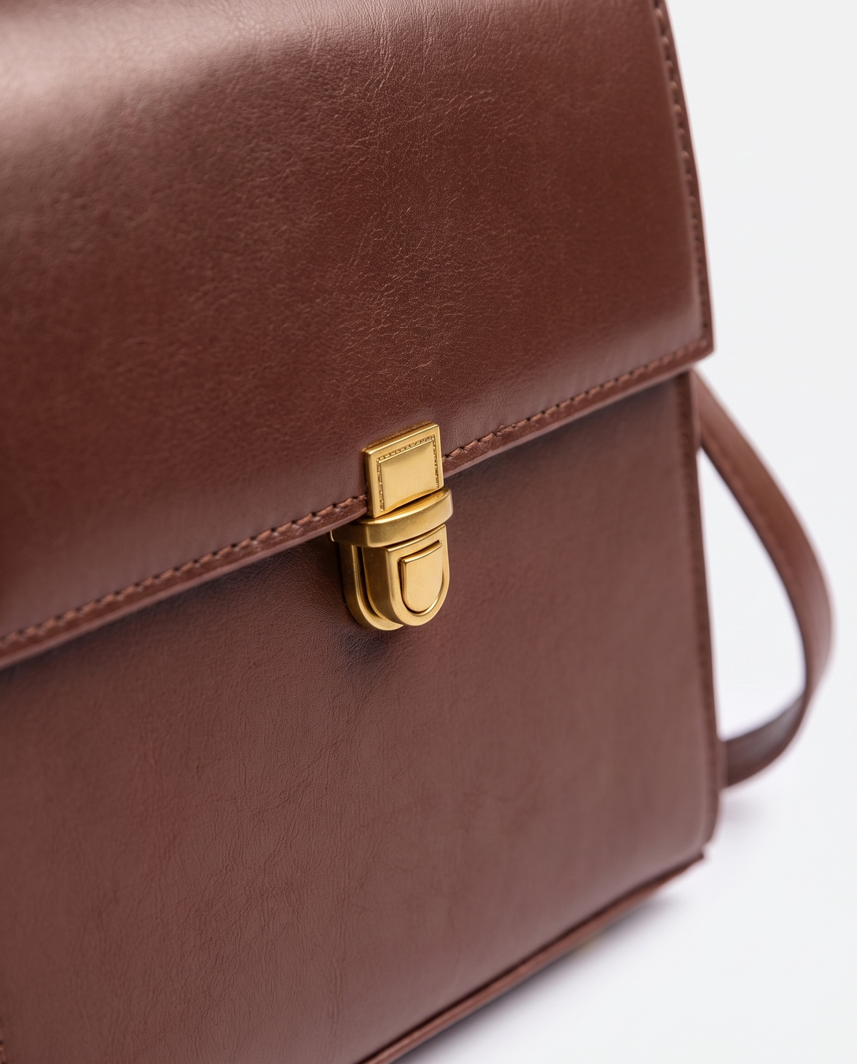 Bloc square vegan leather crossbody bag in Brown – close-up of the gold push-lock clasp