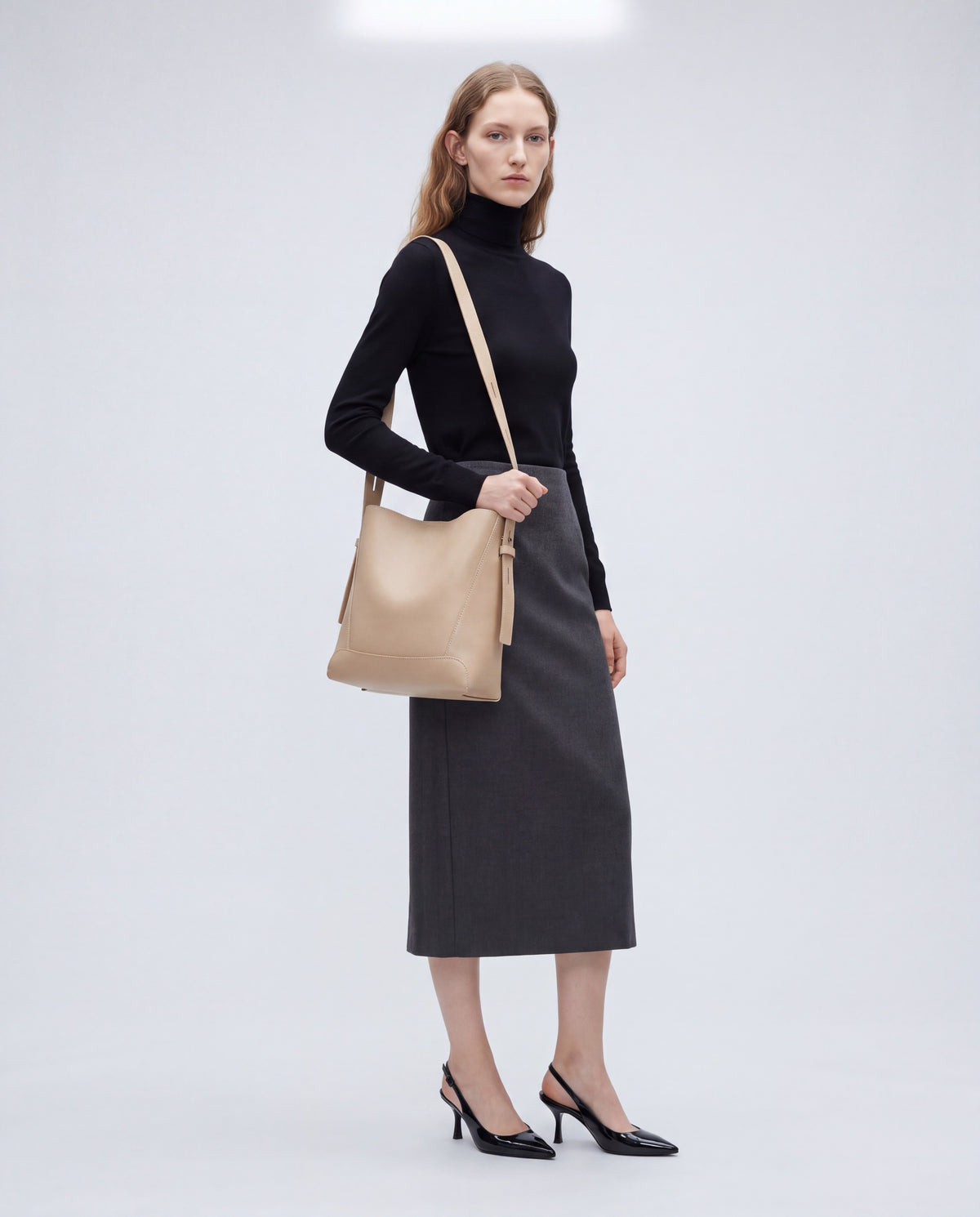Calce bag in Beige – worn by model, full length