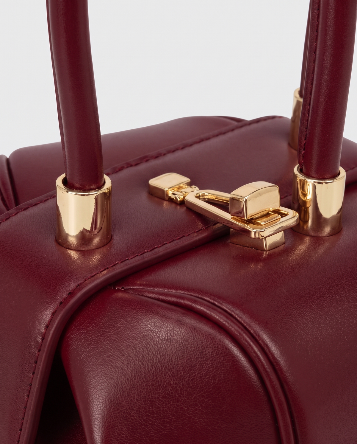 Dumpling Maxi leather top-handle bag in Red – close-up of the gold twist-lock and handle fittings
