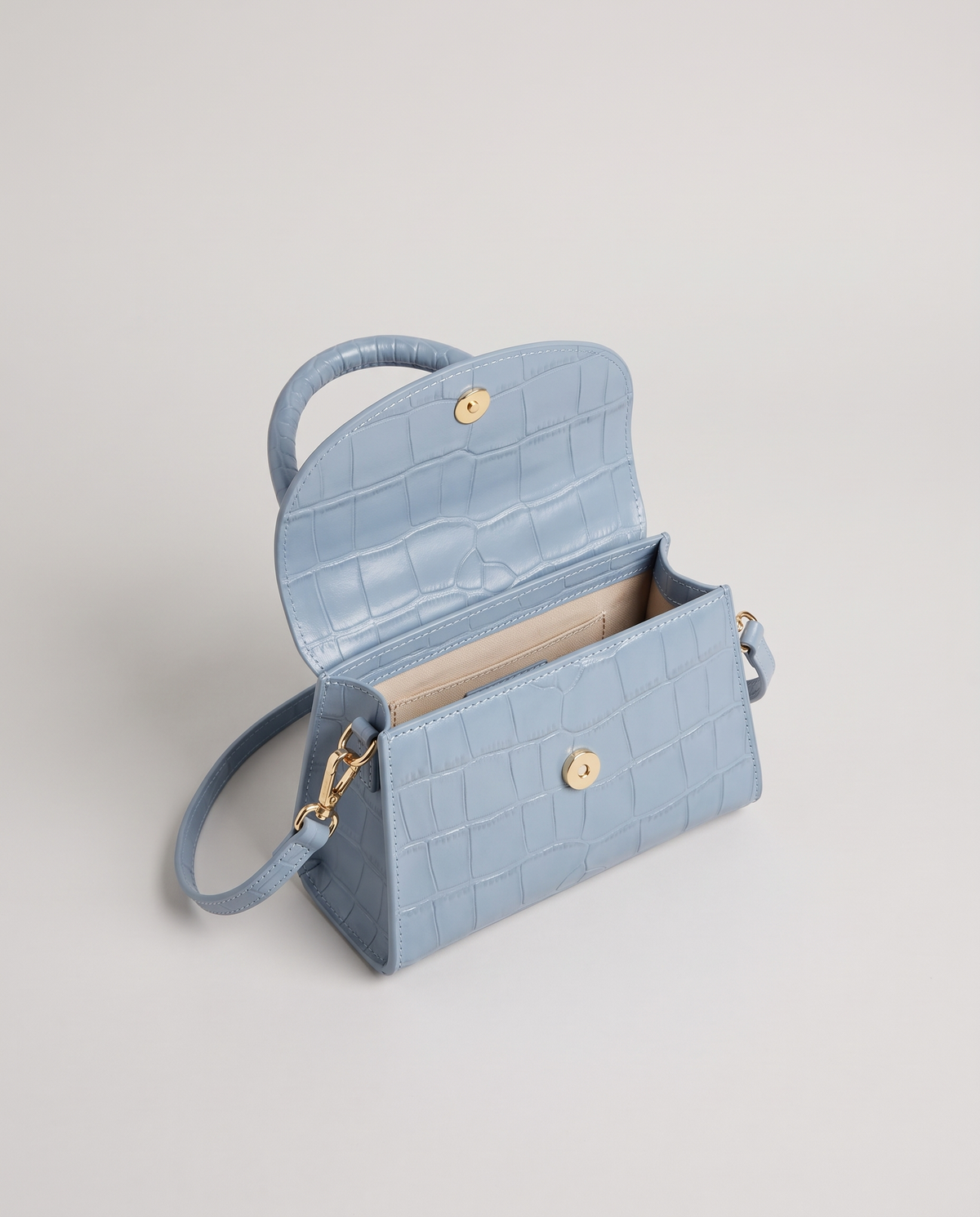 Fern mini croc top-handle bag in Blue – flap open, showing the lined interior