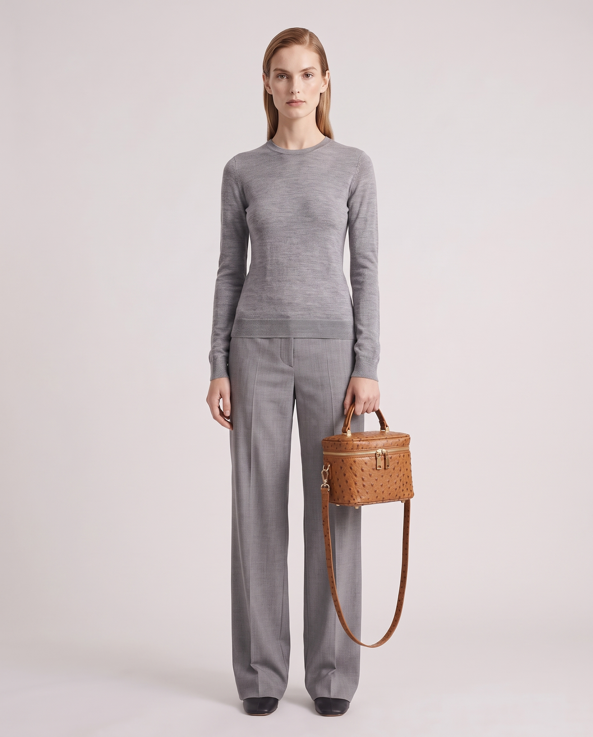 Brindisi ostrich-embossed vanity bag in Cognac – model holding it, full length