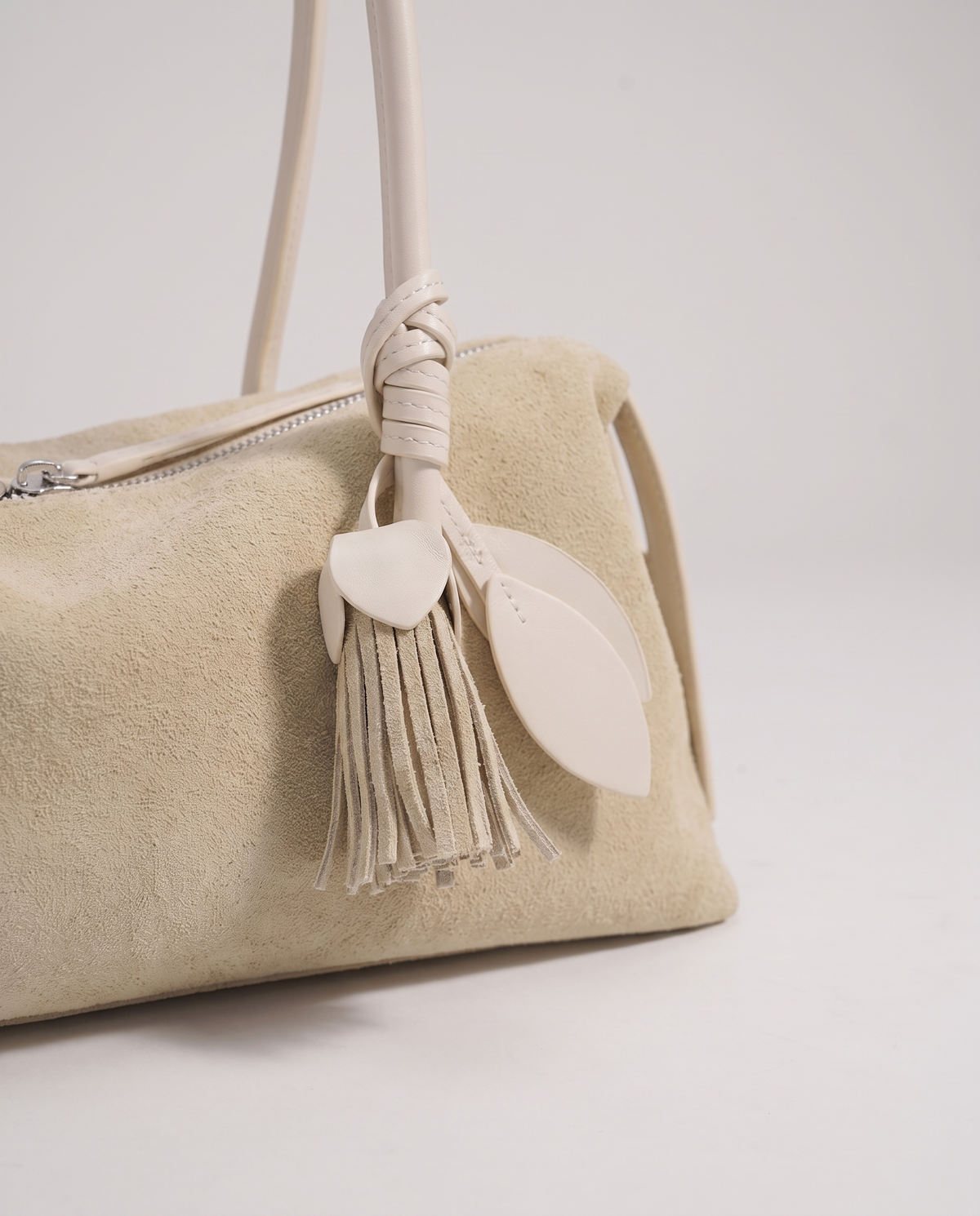 Isola suede shoulder bag in beige, leaf and tassel charm detail