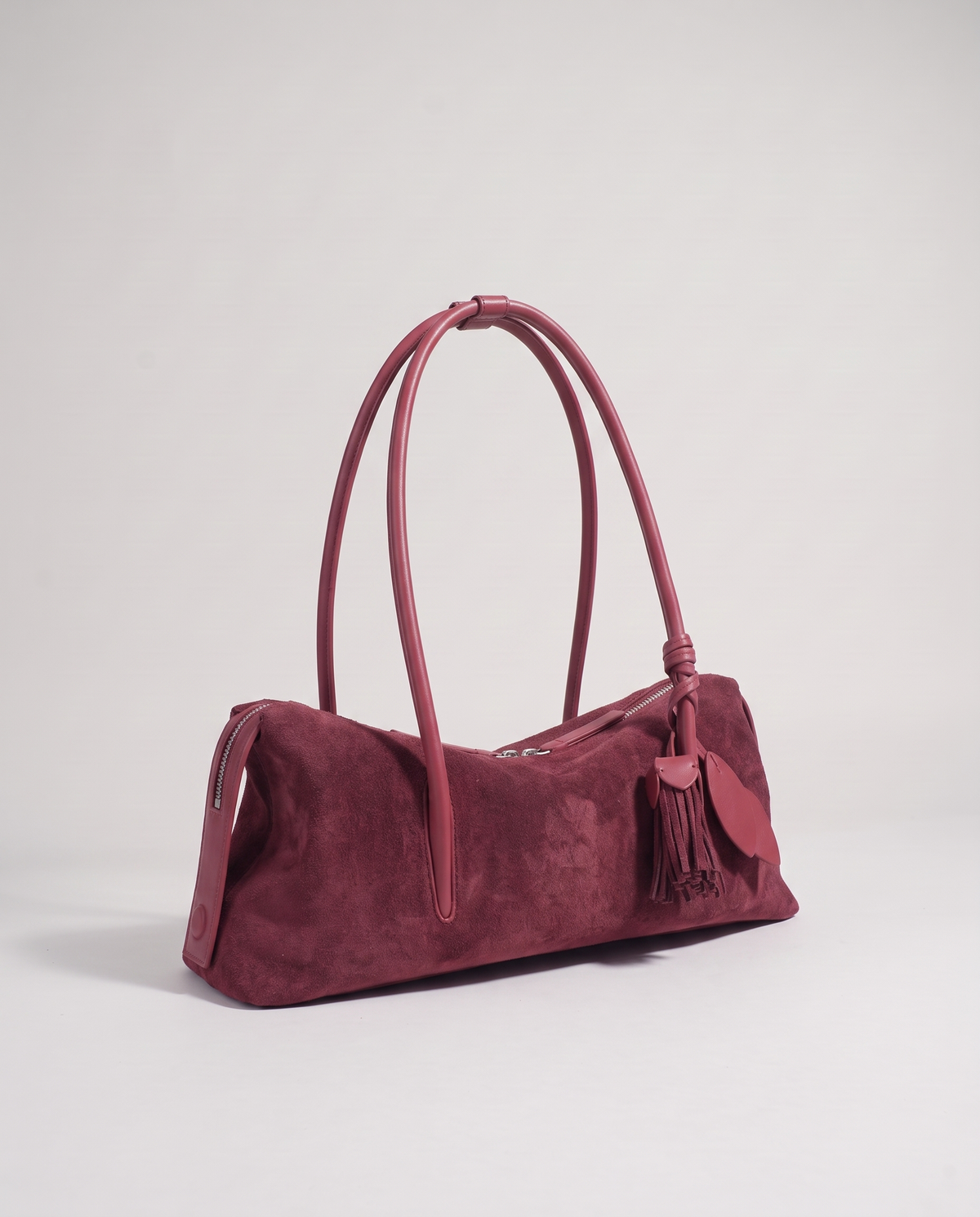 Isola suede shoulder bag in burgundy, three-quarter view