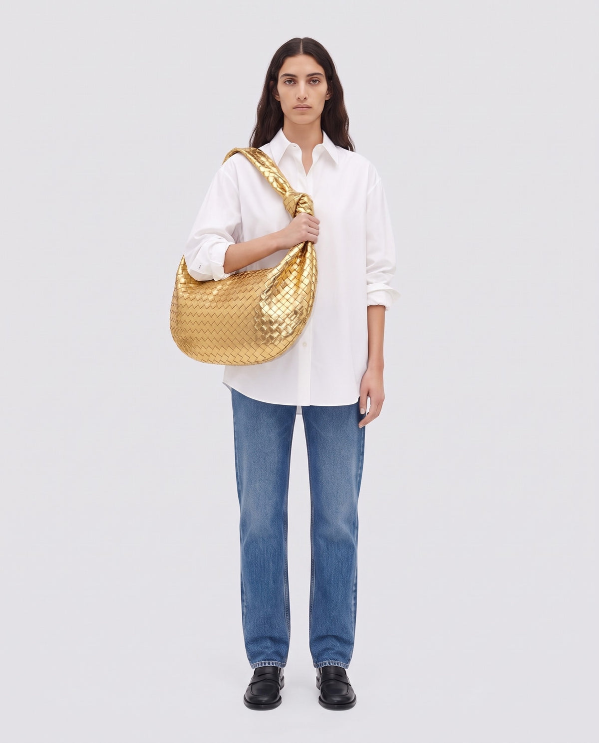 Knot Maxi woven leather shoulder bag in Gold – model wearing it on the shoulder, full length