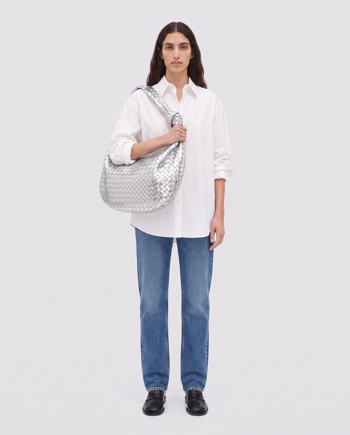 Knot Maxi woven leather shoulder bag in Silver – model wearing it on the shoulder, full length