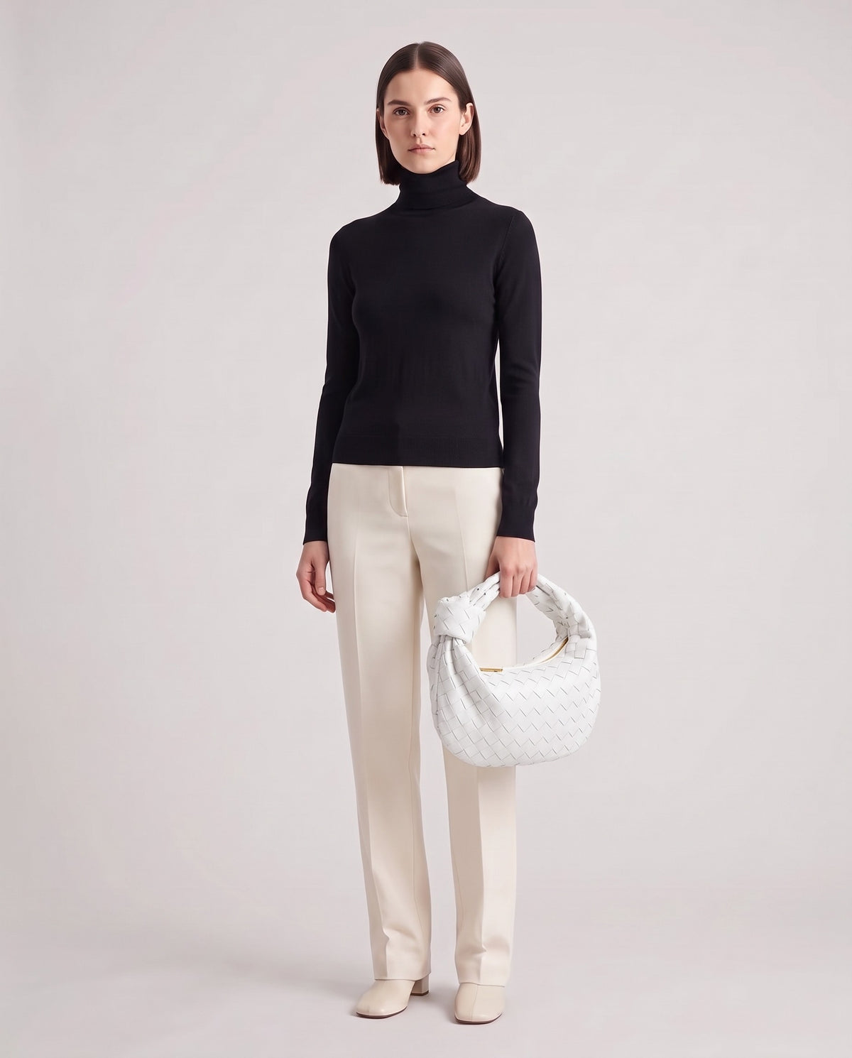 Knot Midi woven leather bag in White – model holding it, full length