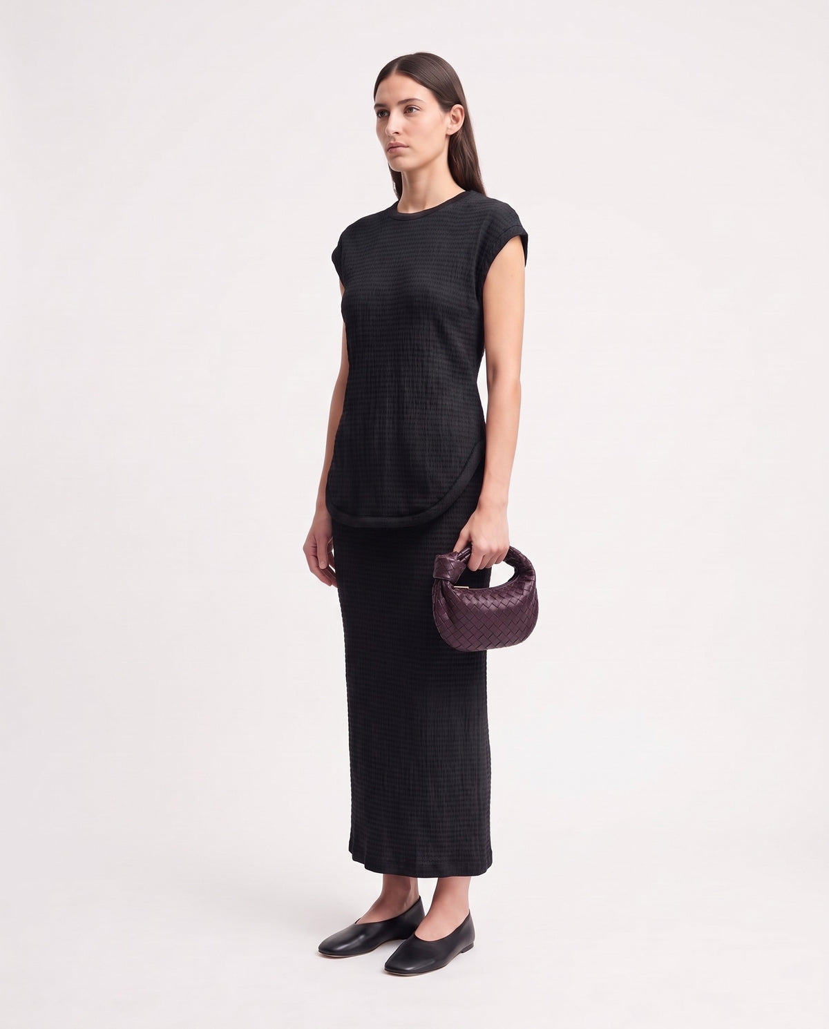 Knot Mini woven leather bag in Bordeaux – model holding it, full length