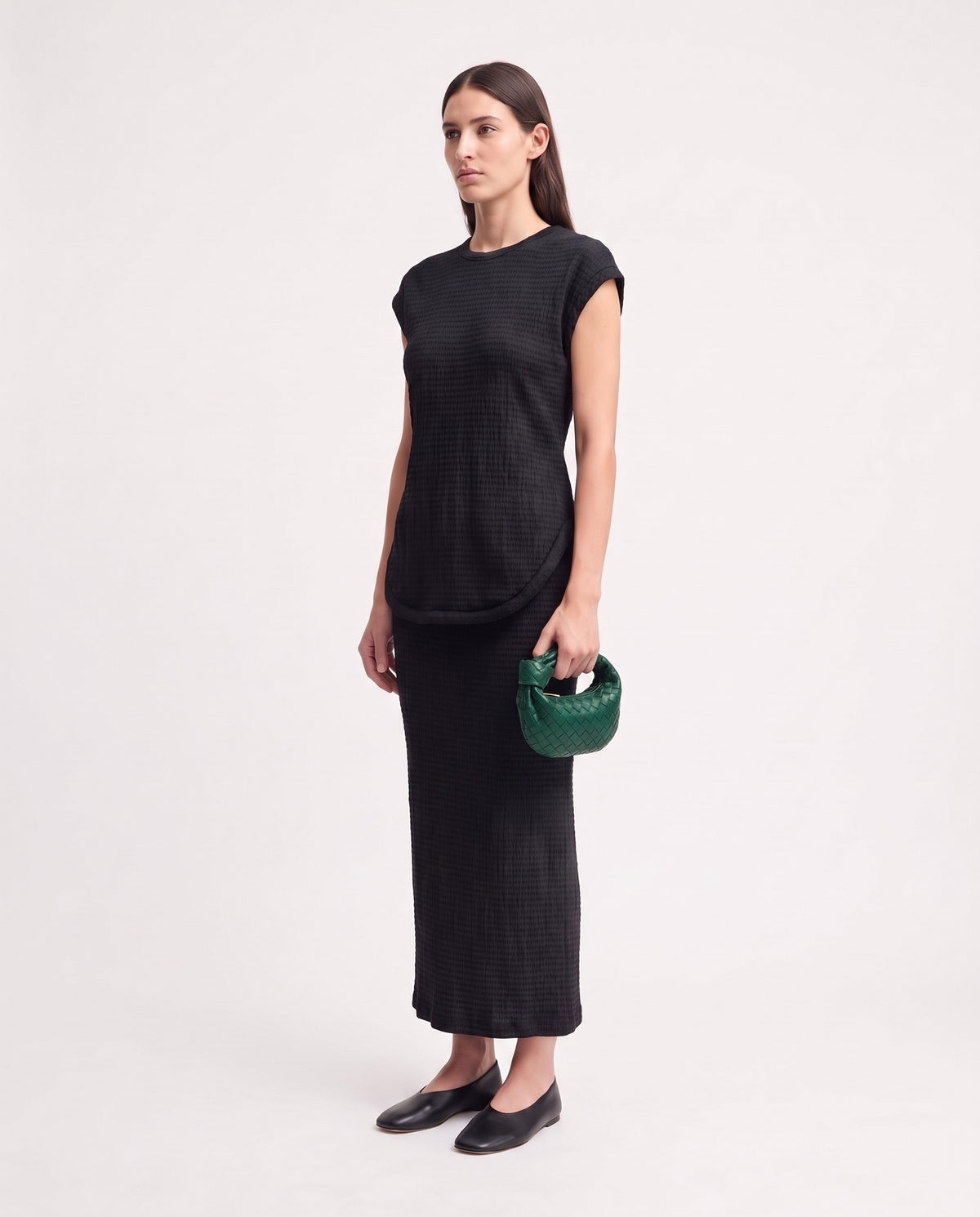 Knot Mini woven leather bag in Emerald – model holding it, full length