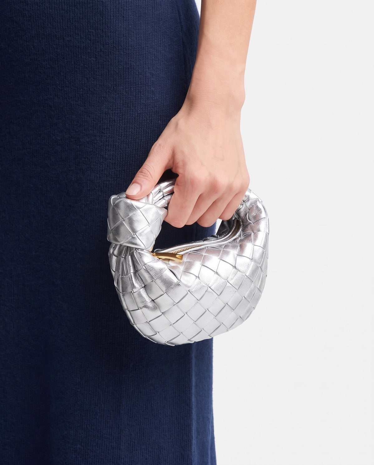 Knot Mini woven leather bag in Silver – held in the hand, showing true size