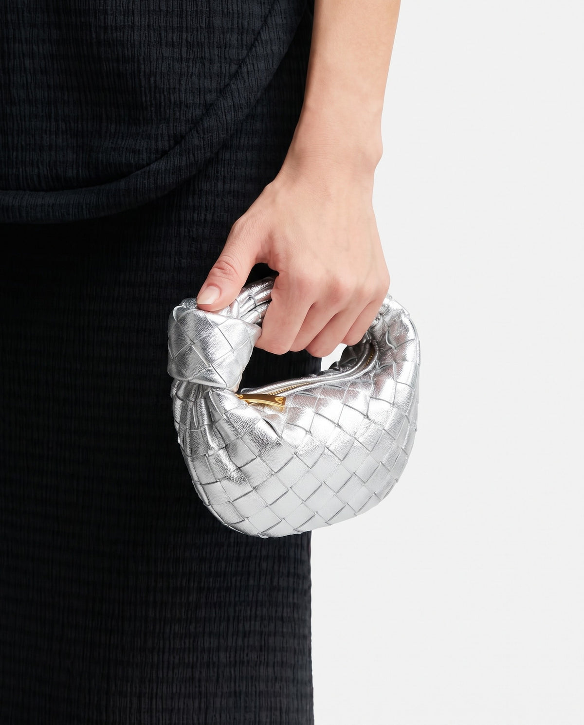Knot Mini woven leather bag in Silver – held in the hand, showing true size