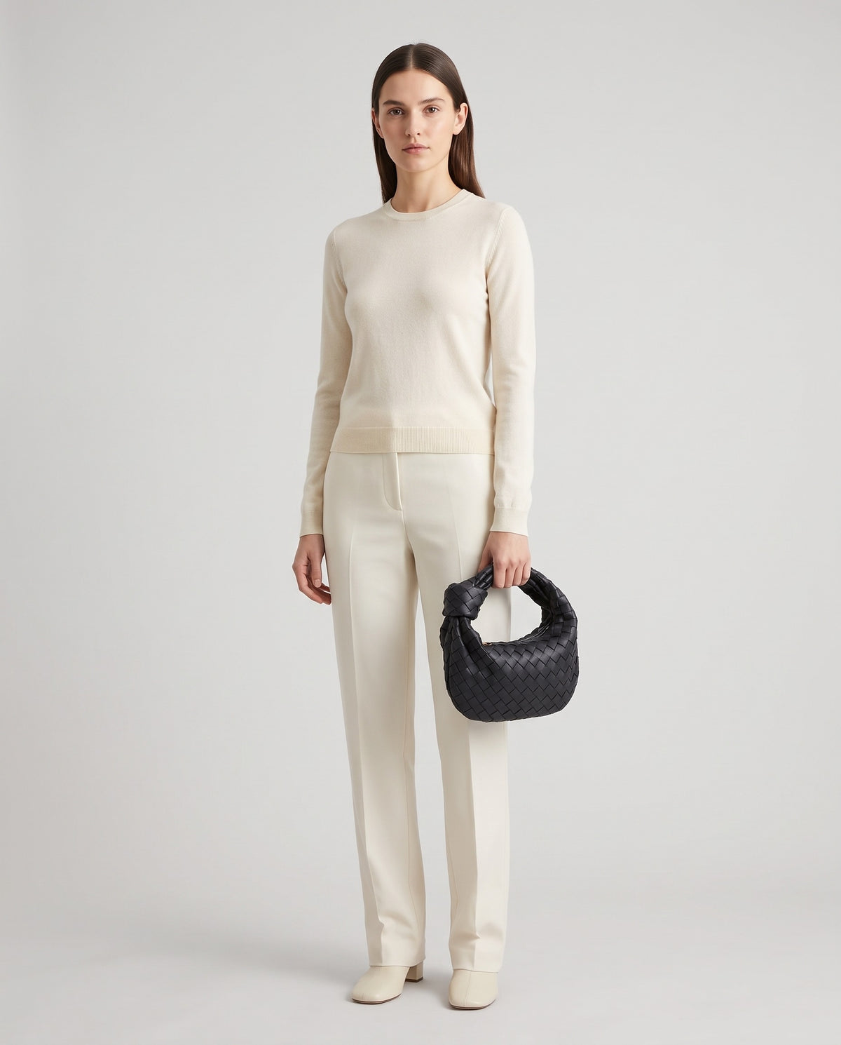 Knot Small woven leather bag in Black – model holding it, full length