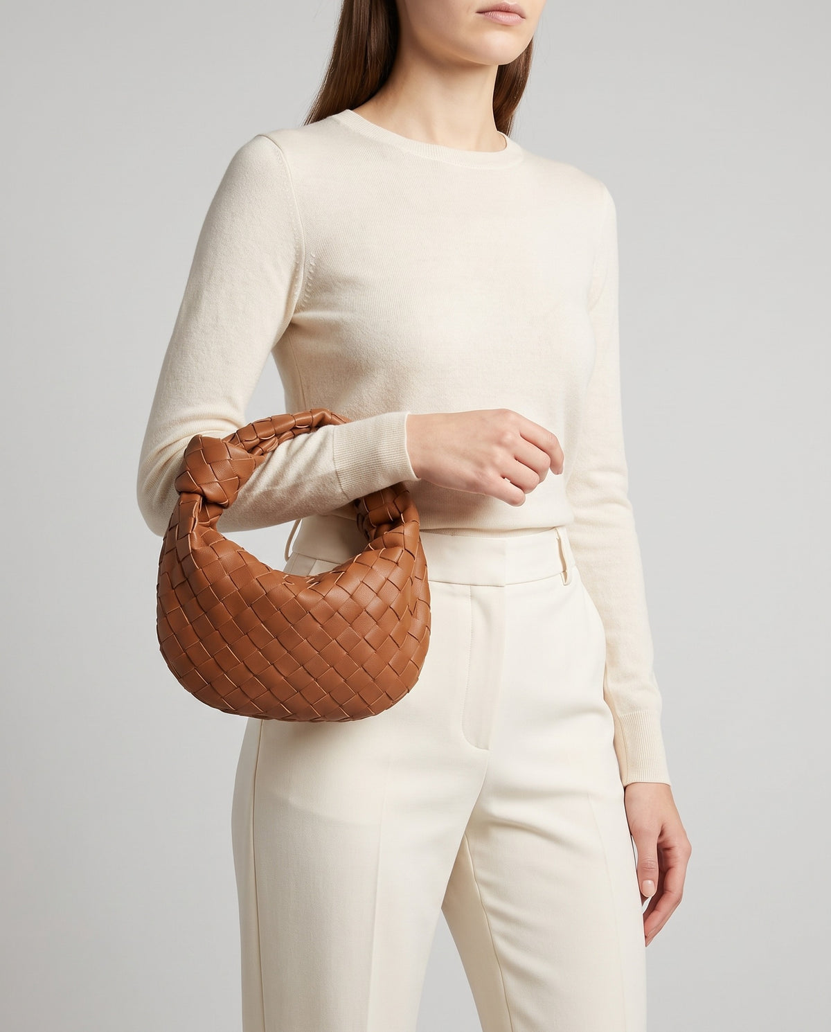 Knot Small woven leather bag in Brown – model carrying it by the knotted handle