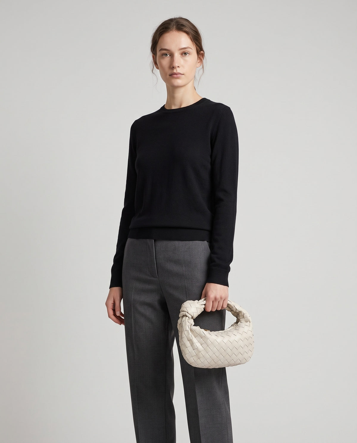 Knot Small woven leather bag in Chalk – model holding it, full length