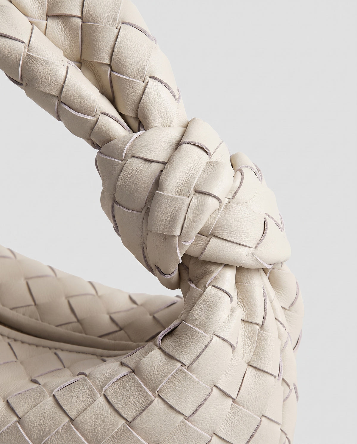 Knot Small woven leather bag in Chalk – close-up of the knotted handle