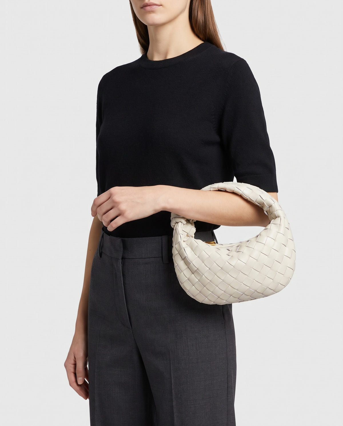 Knot Small woven leather bag in Chalk – model carrying it by the knotted handle