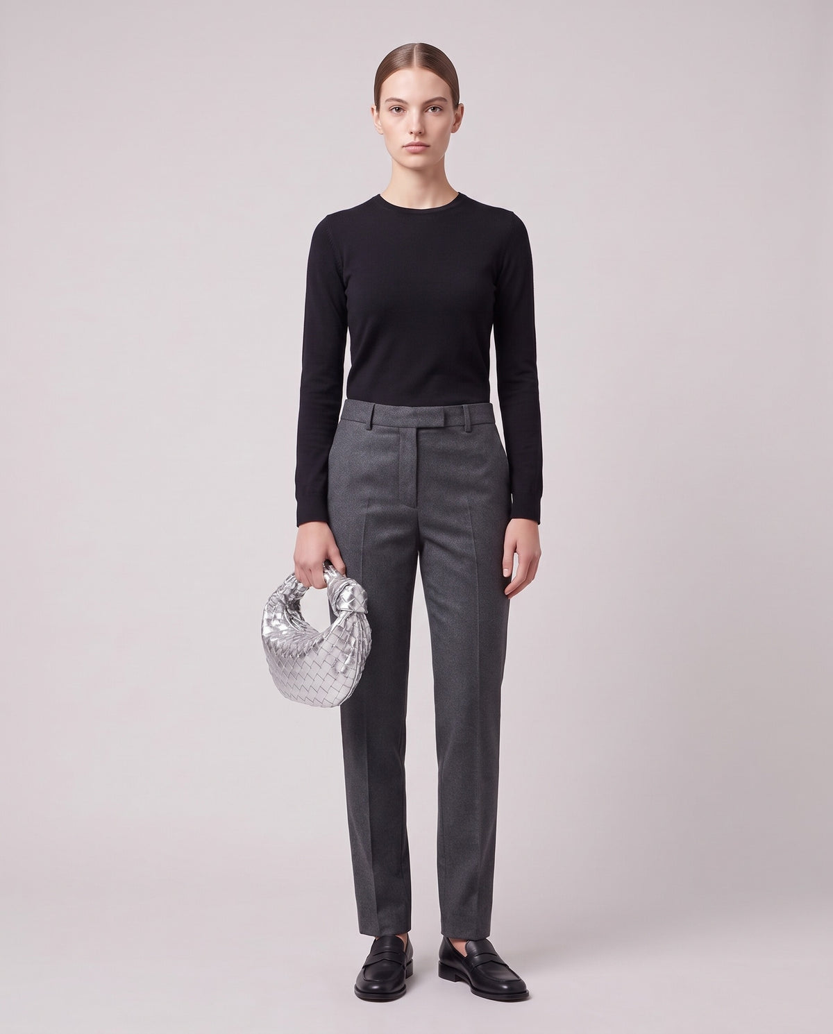 Model holding the Knot Small woven leather bag in Silver – full length