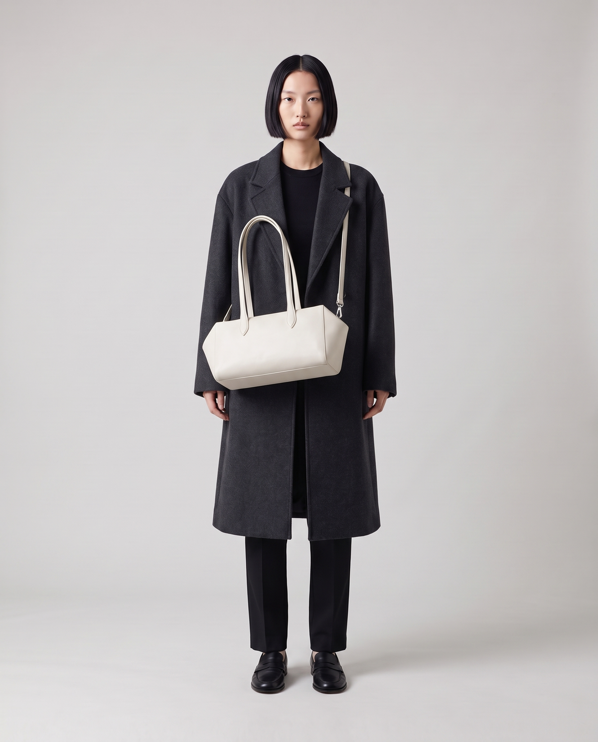 Lira leather shoulder bag in White – model wearing it on her shoulder, full length