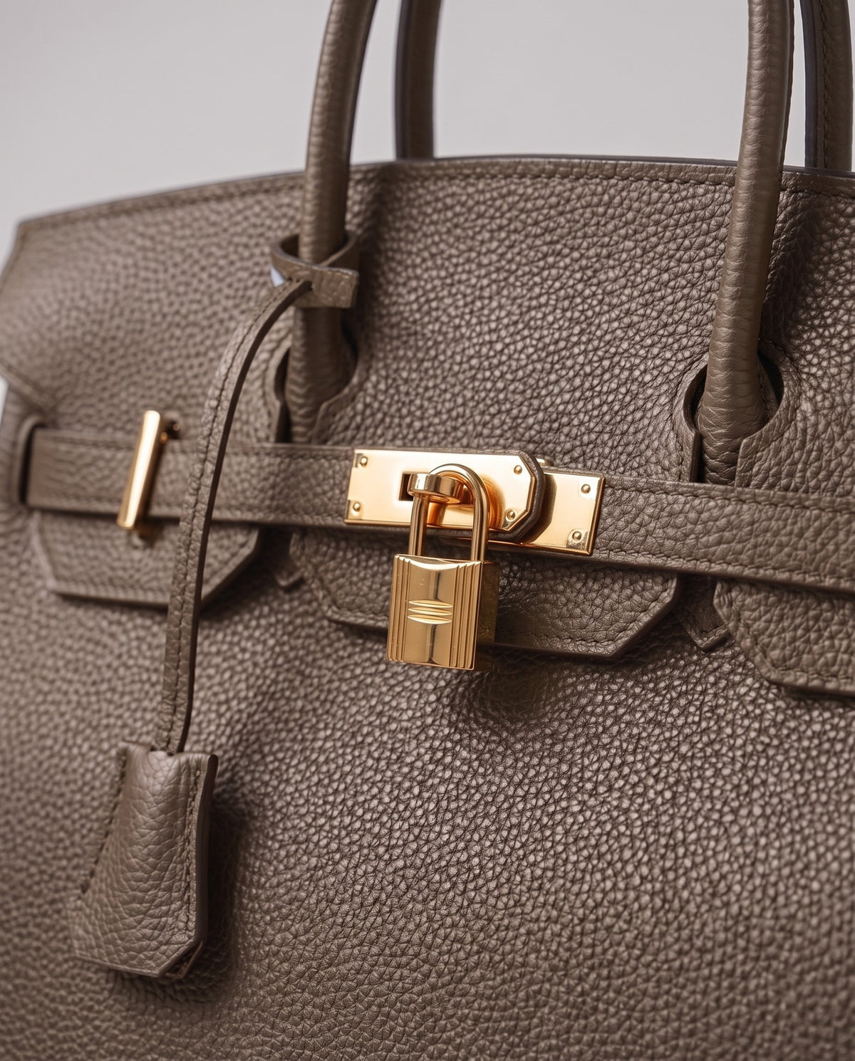 Lock Extra Large leather top-handle bag in Taupe – close-up of the gold turn-lock and padlock