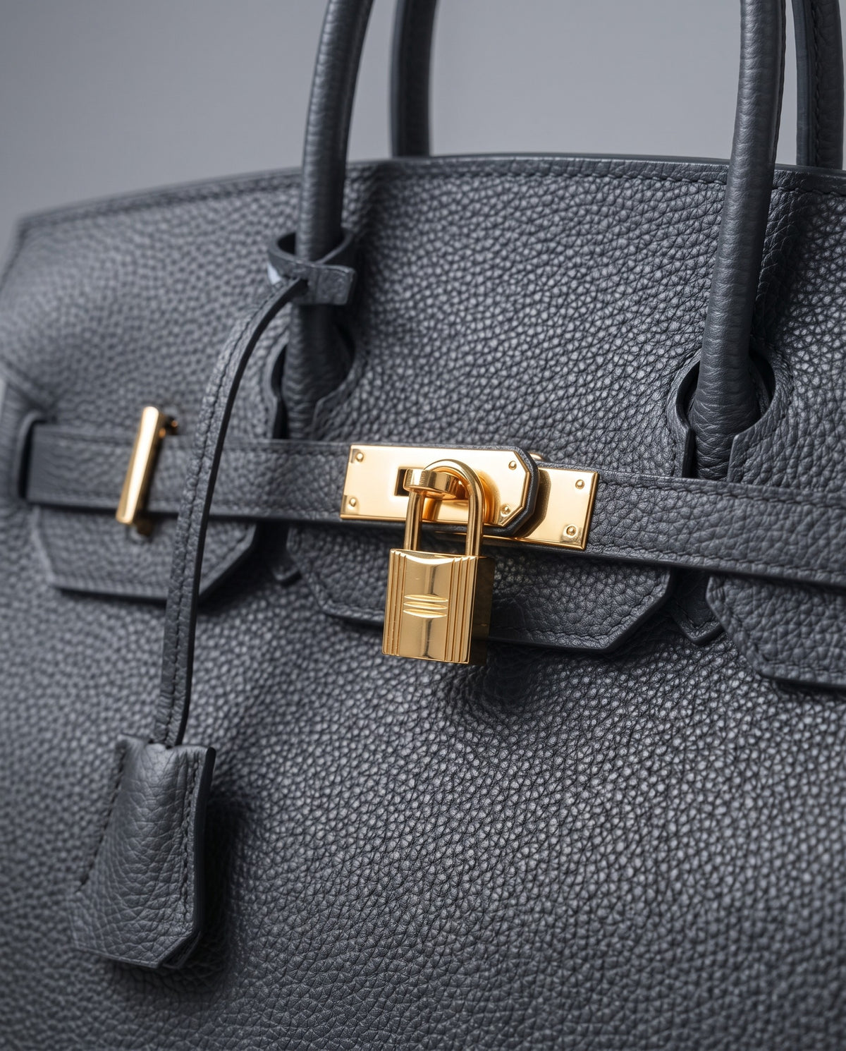 Lock Large leather top-handle bag in Charcoal – close-up of the gold turn-lock and padlock