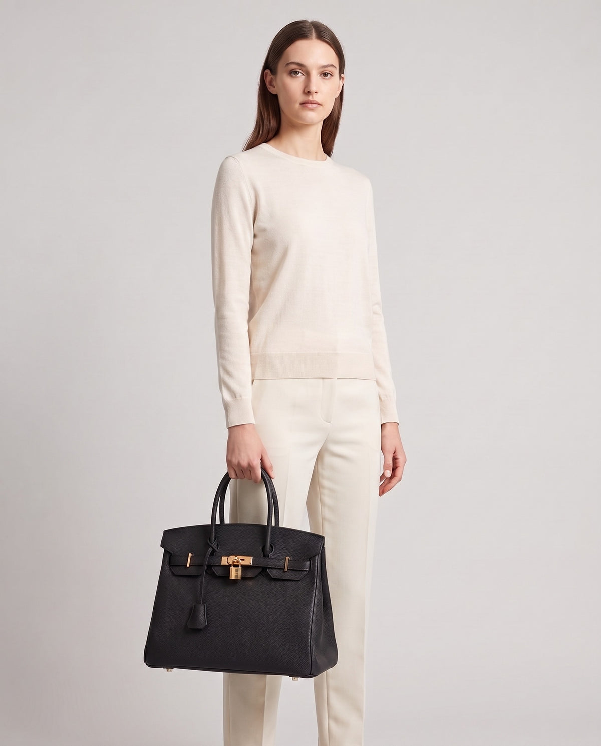 Lock Medium leather top-handle bag in Black – model holding it, full length