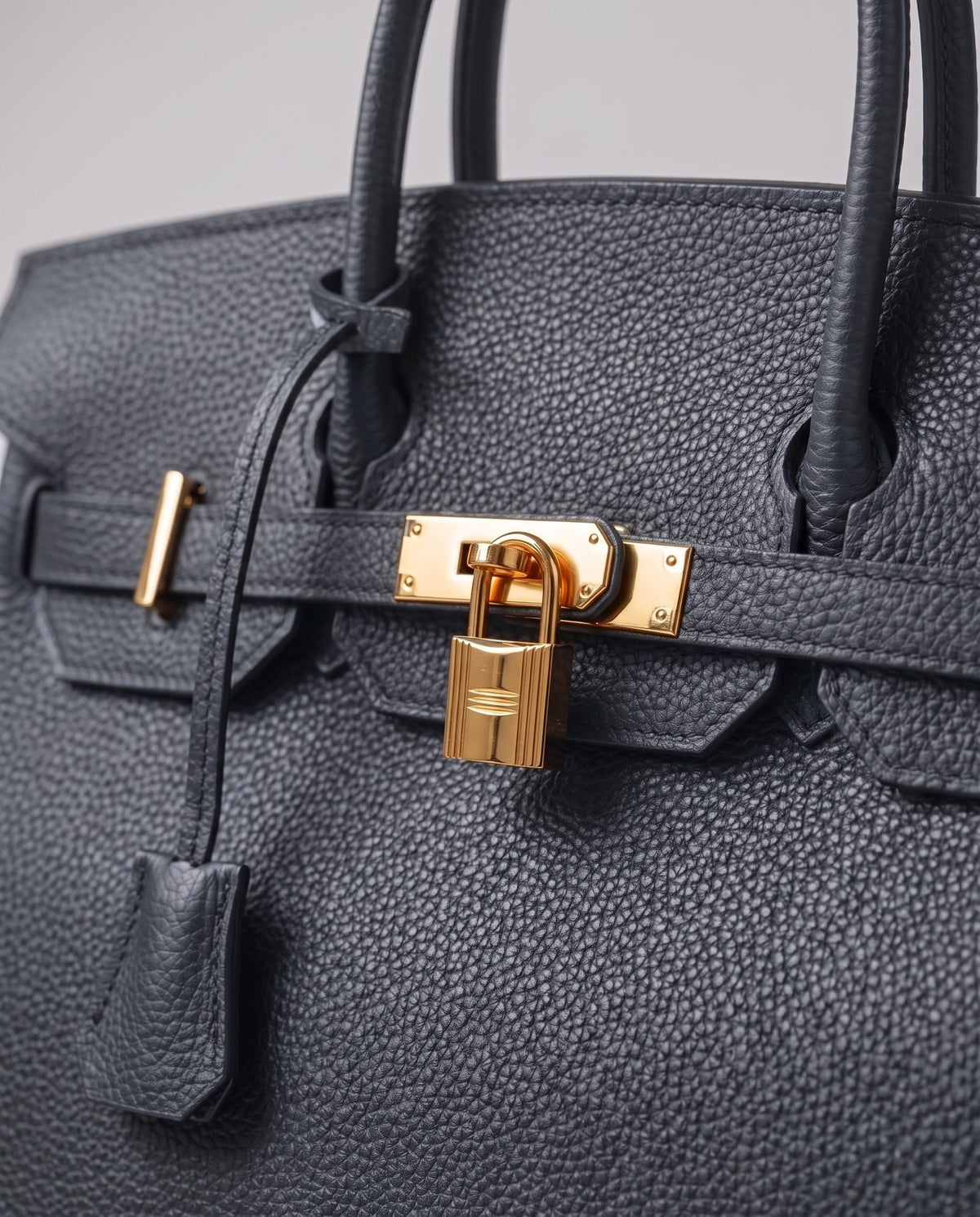Lock Medium leather top-handle bag in Charcoal – close-up of the gold turn-lock and padlock