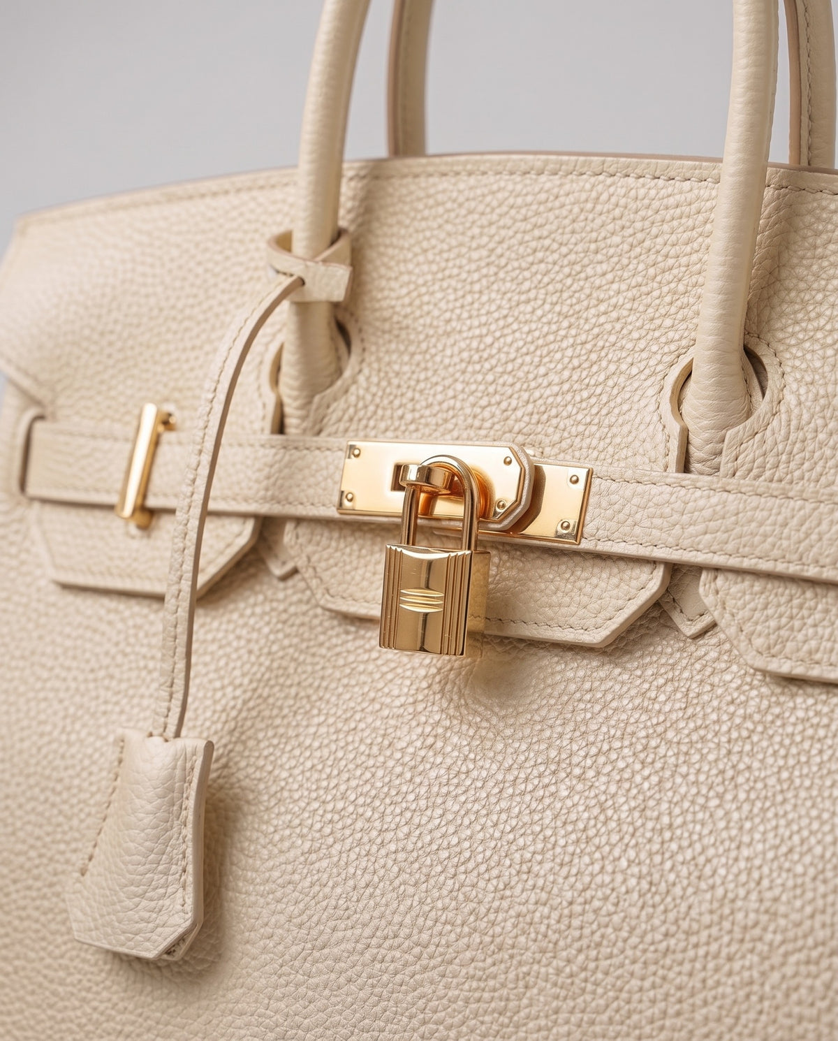 Lock Medium leather top-handle bag in Cream – close-up of the gold turn-lock and padlock