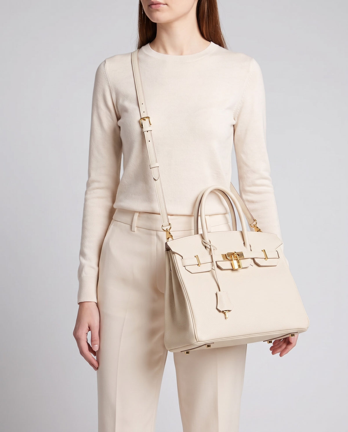 Lock Medium leather top-handle bag in Cream – model wearing it crossbody on the detachable shoulder strap